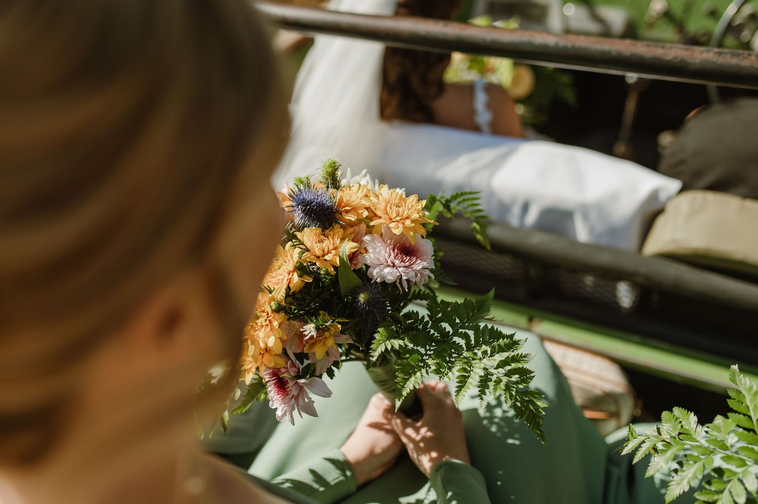 Wedding decorations and flowers adorn a vintage green safari vehicle.