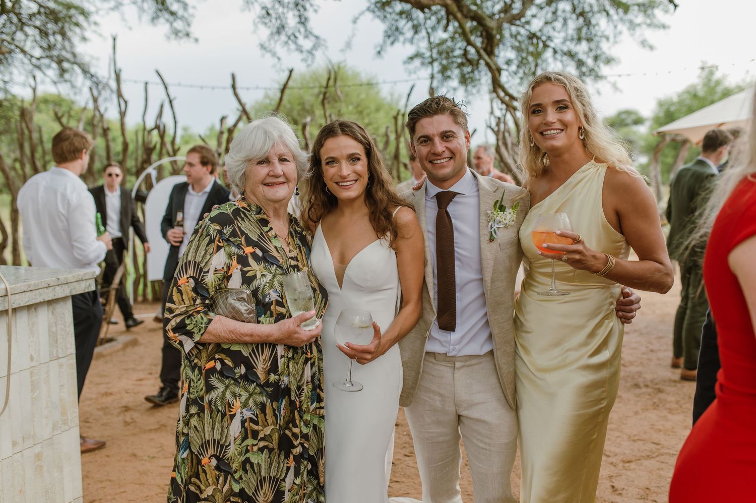 Outdoor party scene with guests mingling under string lights and natural decor.