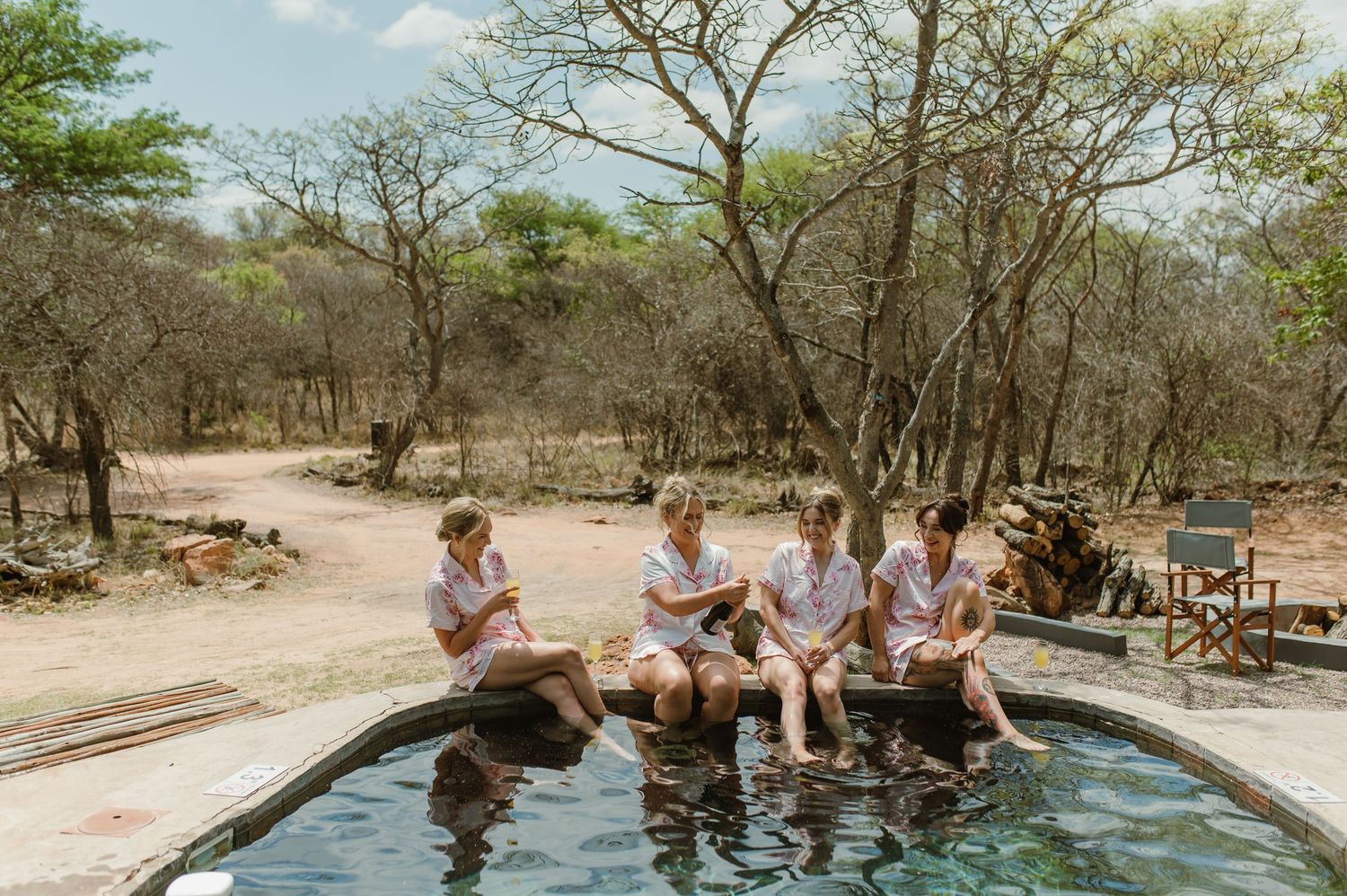 Group enjoying a refreshing dip in an outdoor pool surrounded by natural bushland.