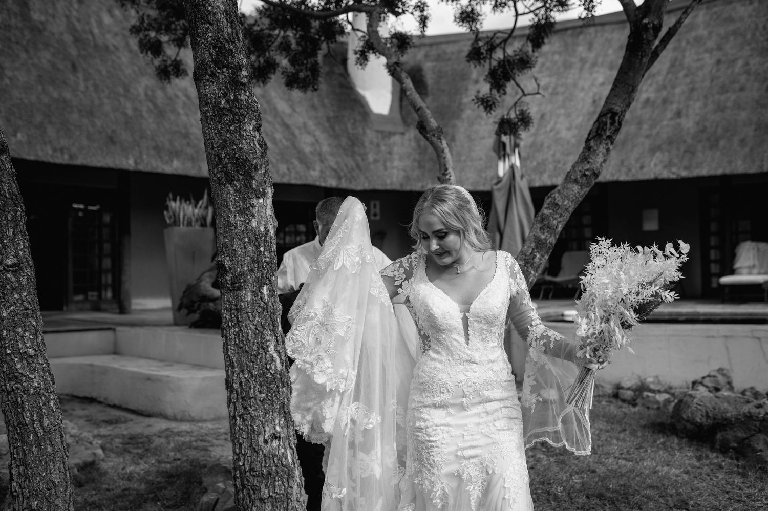 Black and white wedding photos captured in an outdoor garden setting with trees.