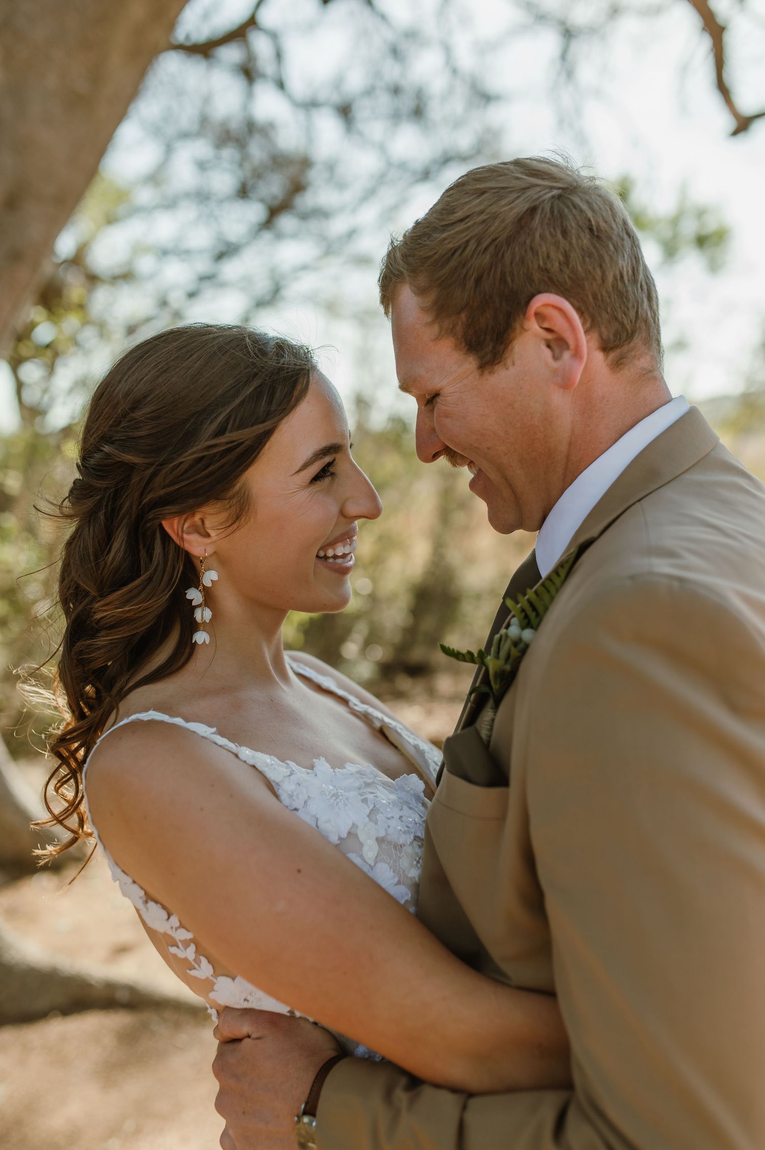 Candid wedding moments captured in warm sunlight under a tree canopy.