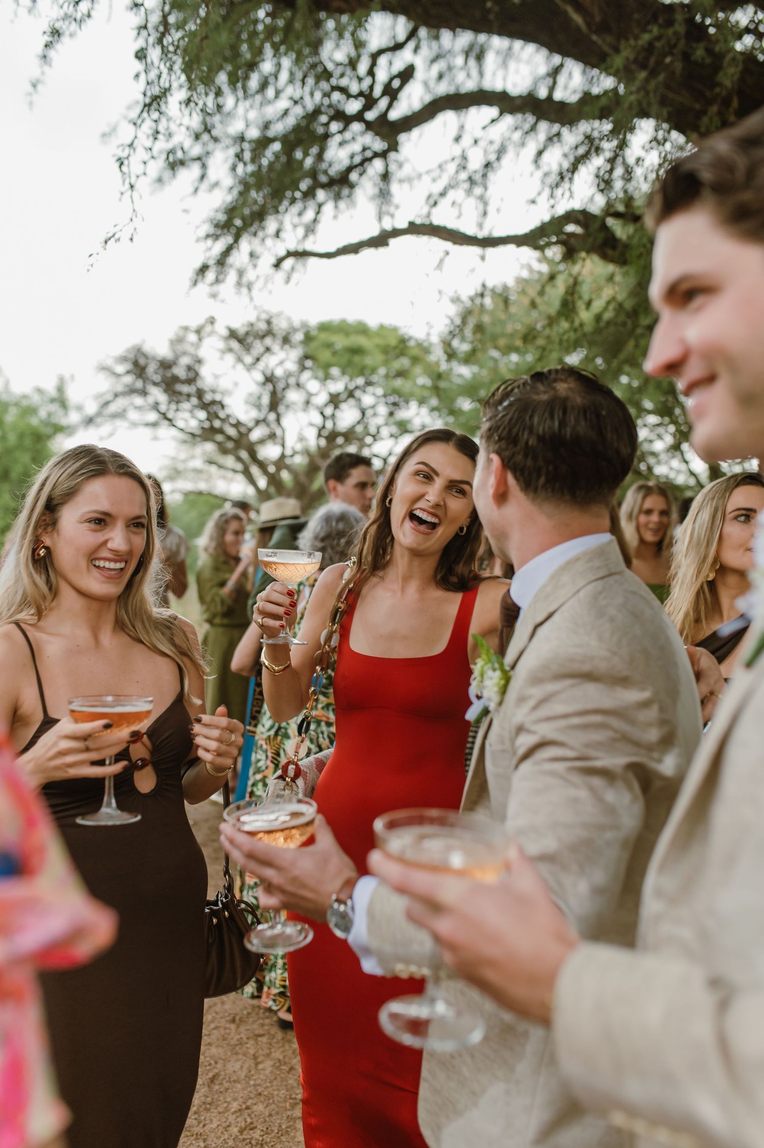Wedding guests enjoying drinks and conversation at an outdoor celebration.