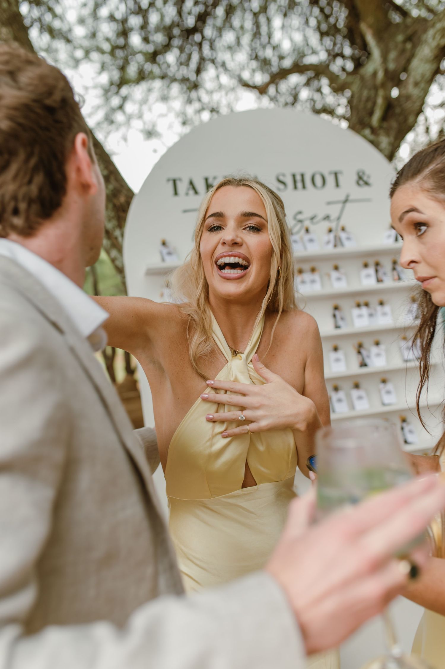 Guests enjoying a festive outdoor celebration with laughter and animated expressions.