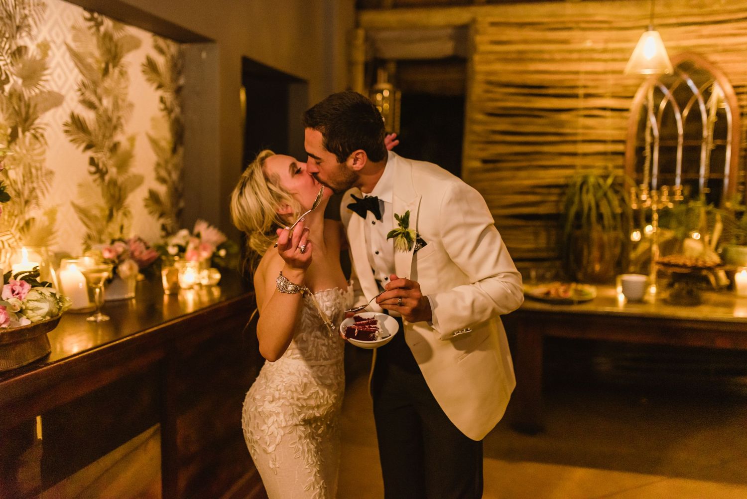 Wedding reception detail showing elegant table settings and decor in warm candlelight.