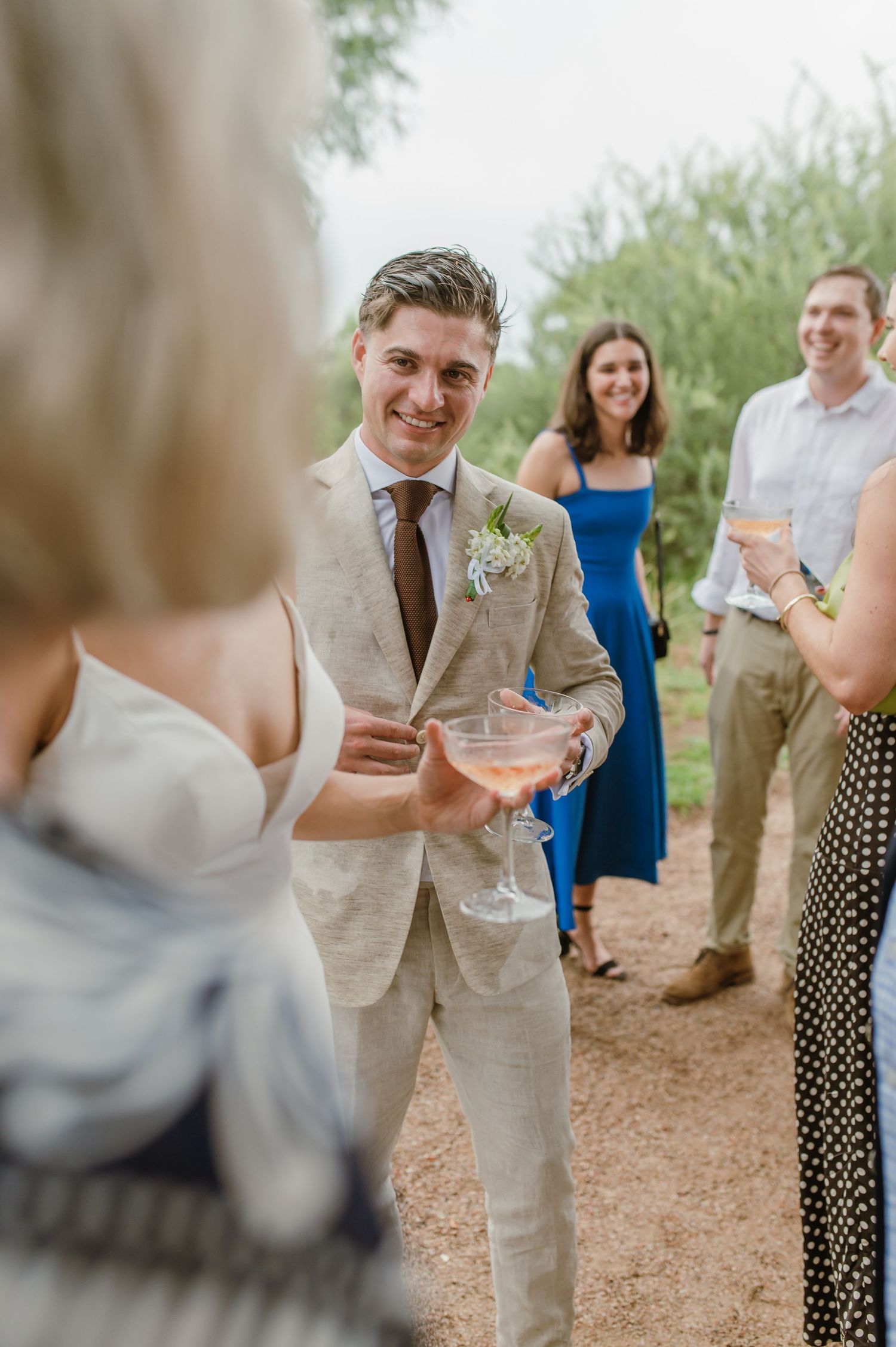 Wedding guests socializing at an outdoor desert venue.