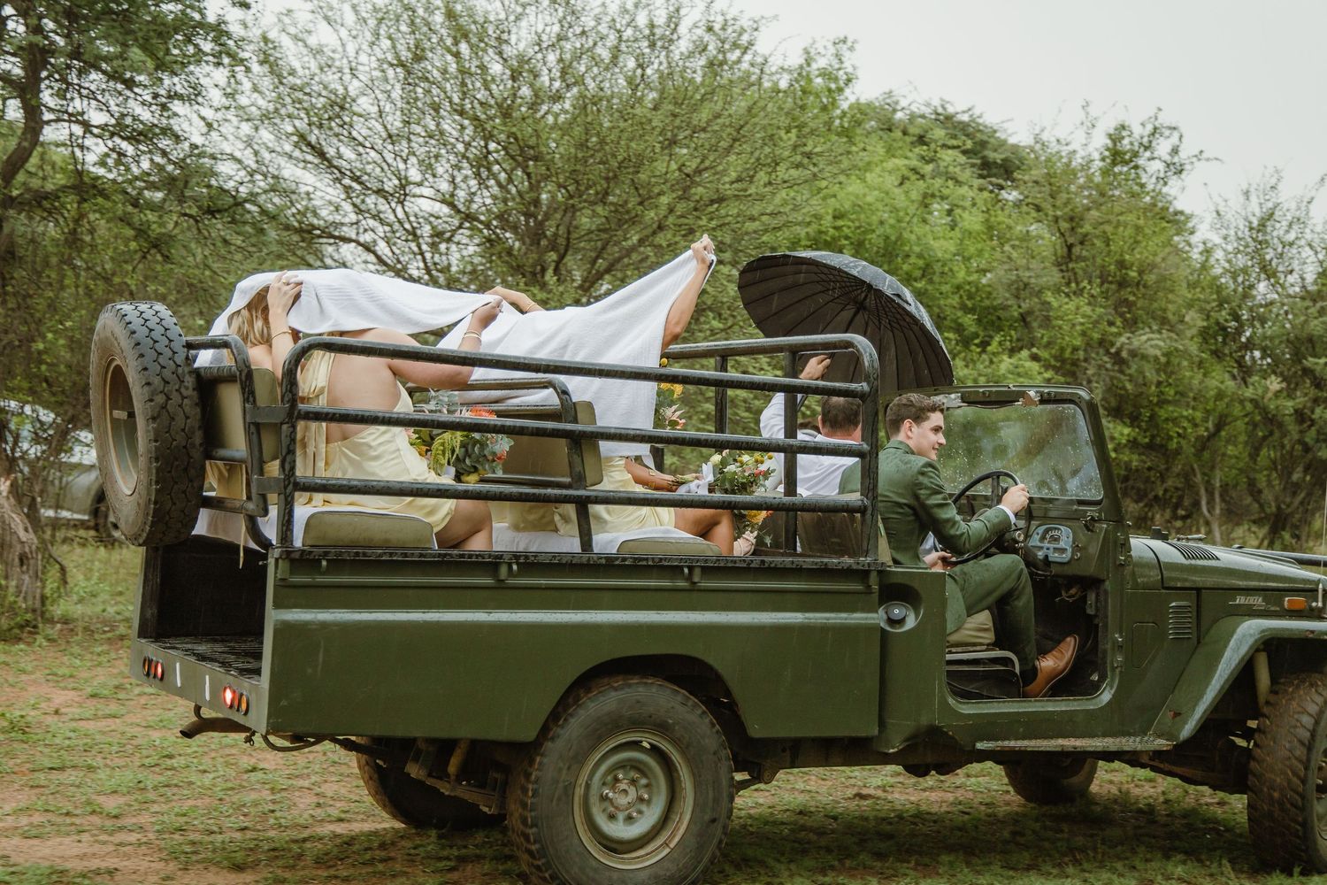 Vintage military-style vehicles parked in line at an outdoor wedding venue.