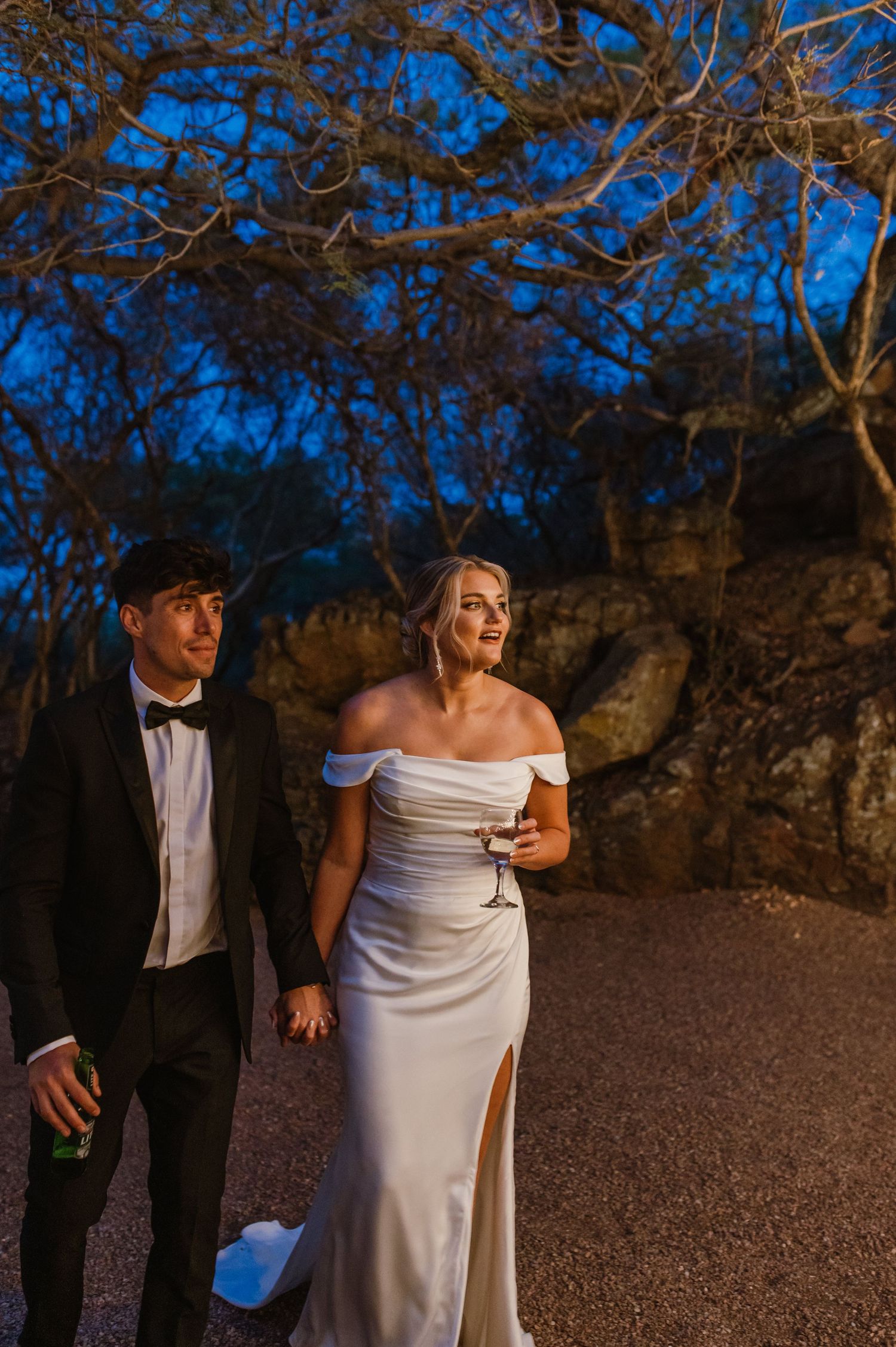 Couple shares intimate moment during outdoor evening wedding ceremony.