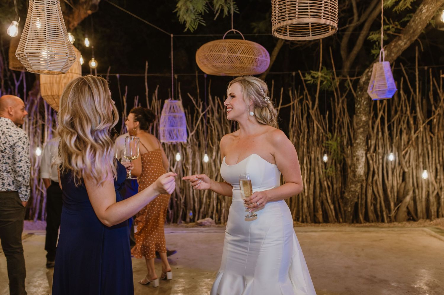 Evening wedding reception with decorative lanterns and natural bamboo wall decorations.