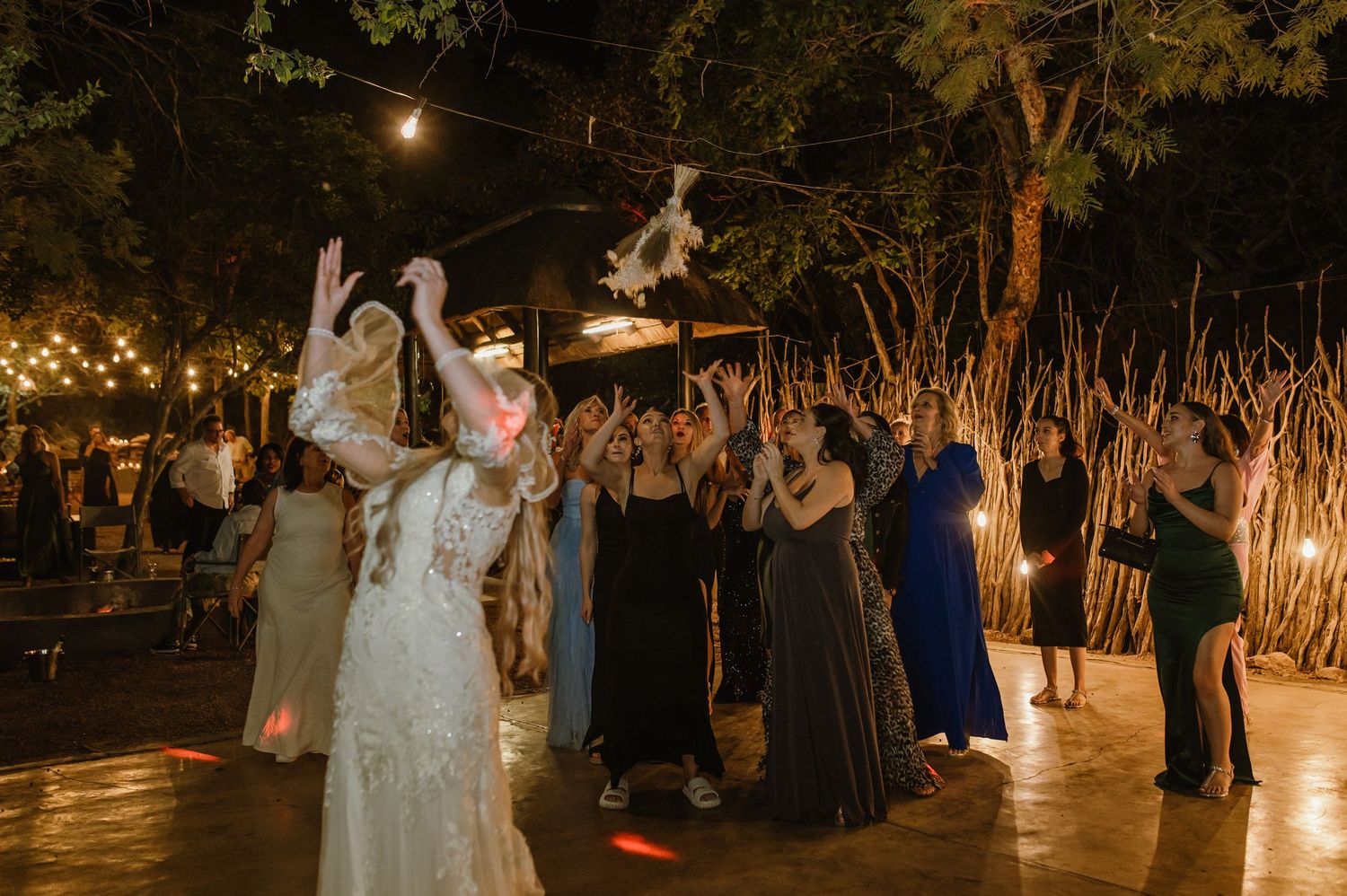 Nighttime wedding celebration with warm lighting and natural outdoor elements creating an enchanted setting.
