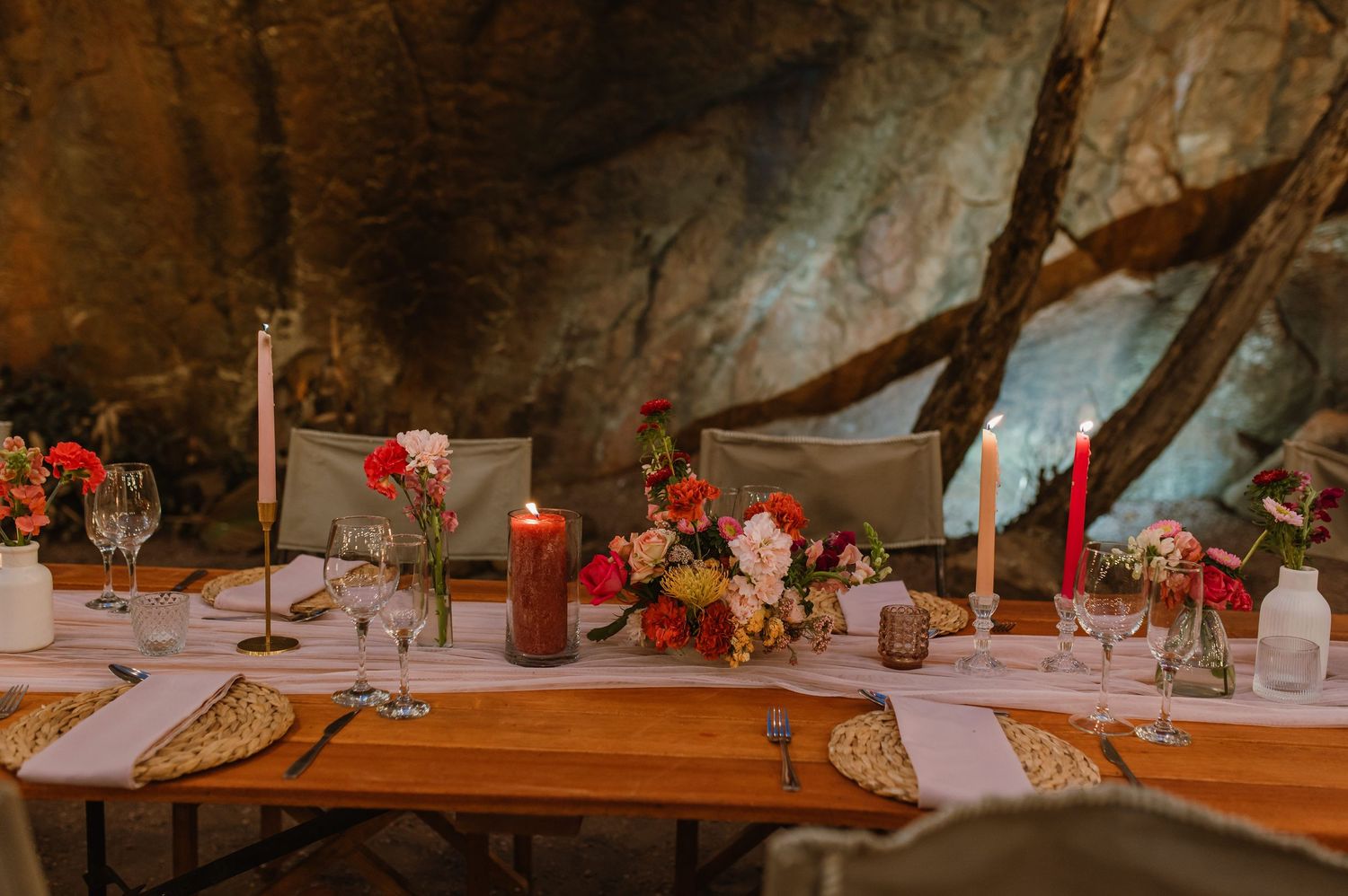 Wedding reception tables decorated with red floral centerpieces and white linens.