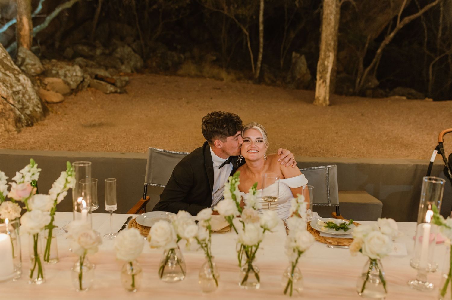 Wedding reception tables decorated with simple floral centerpieces and white linens.