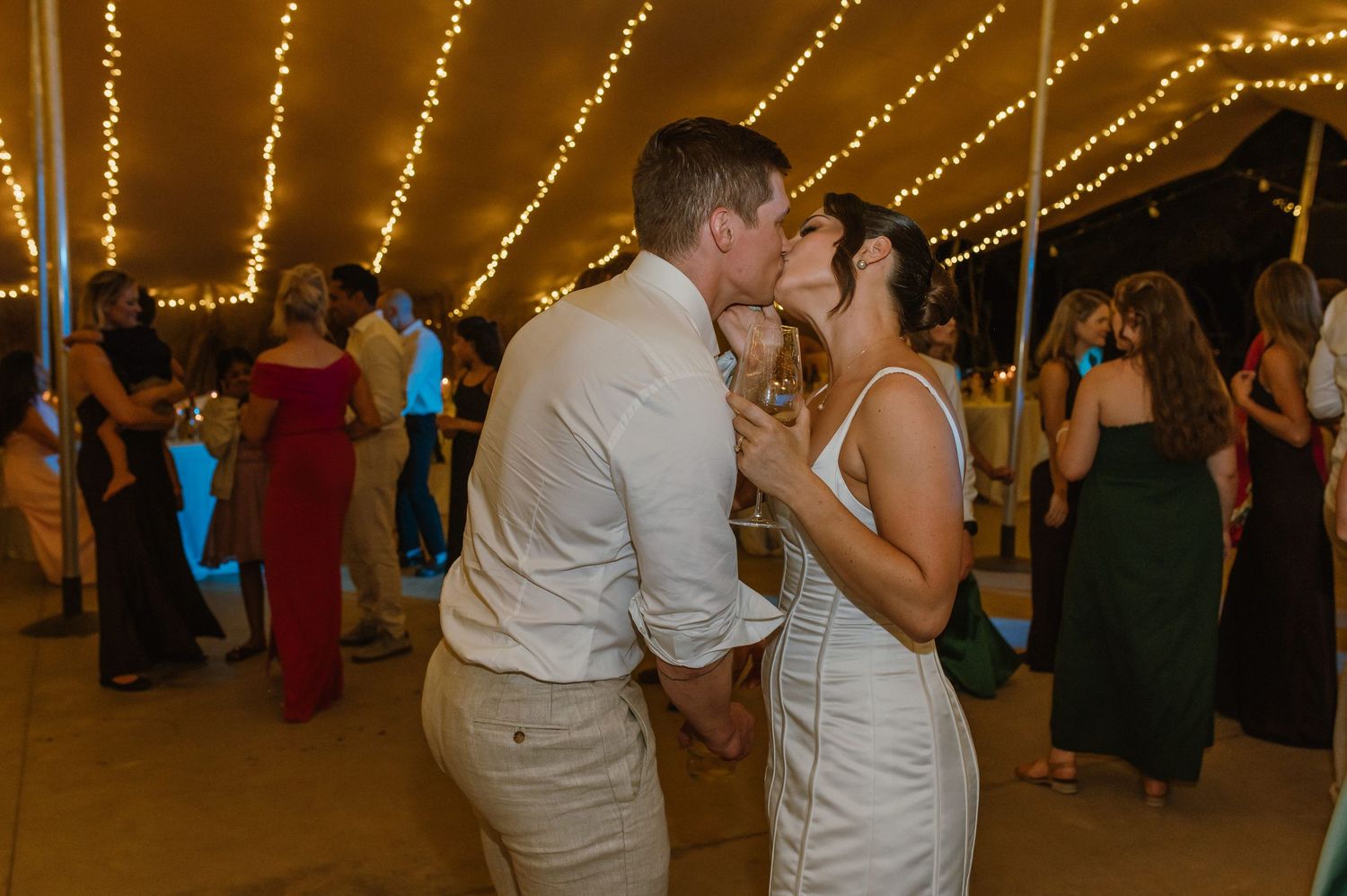 Wedding reception dance floor with guests enjoying the celebration under string lights.