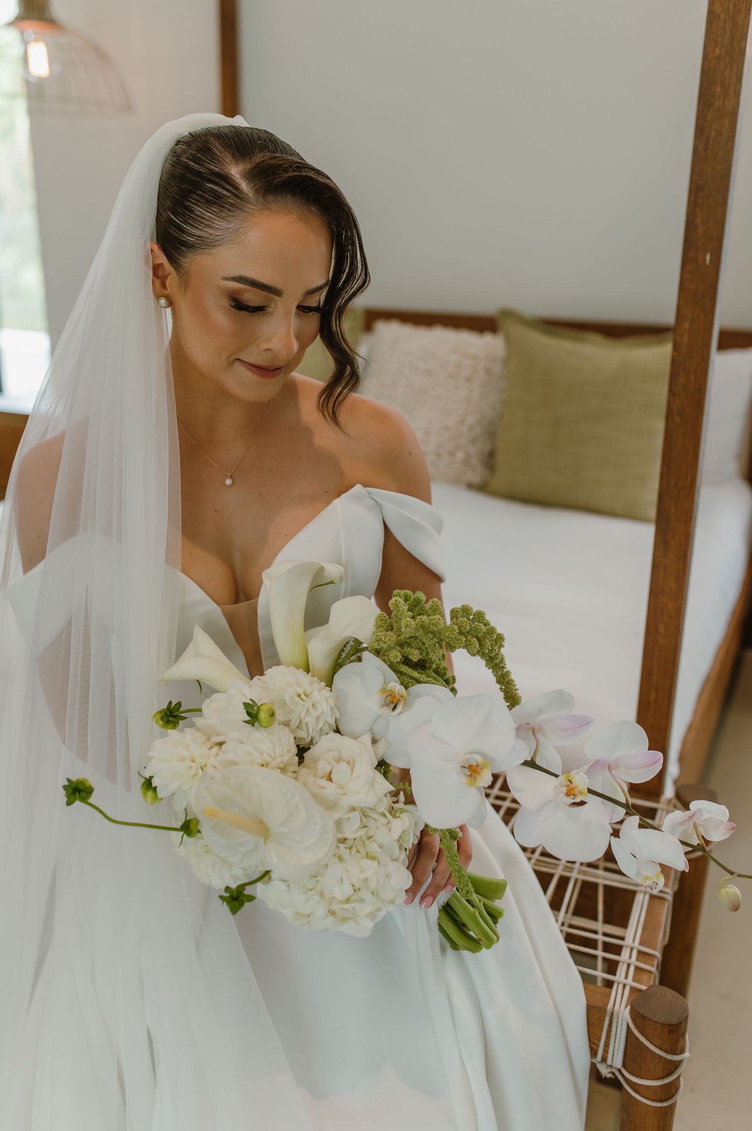 Elegant bridal portrait showing a white wedding gown and stunning bouquet of white and green flowers.
