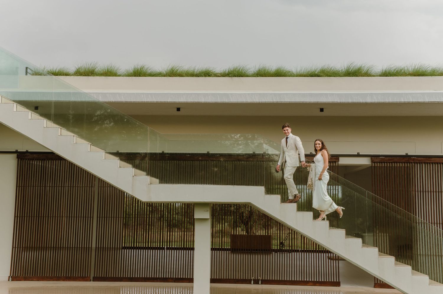 Architectural wedding photos taken at a modern venue with geometric concrete structures.