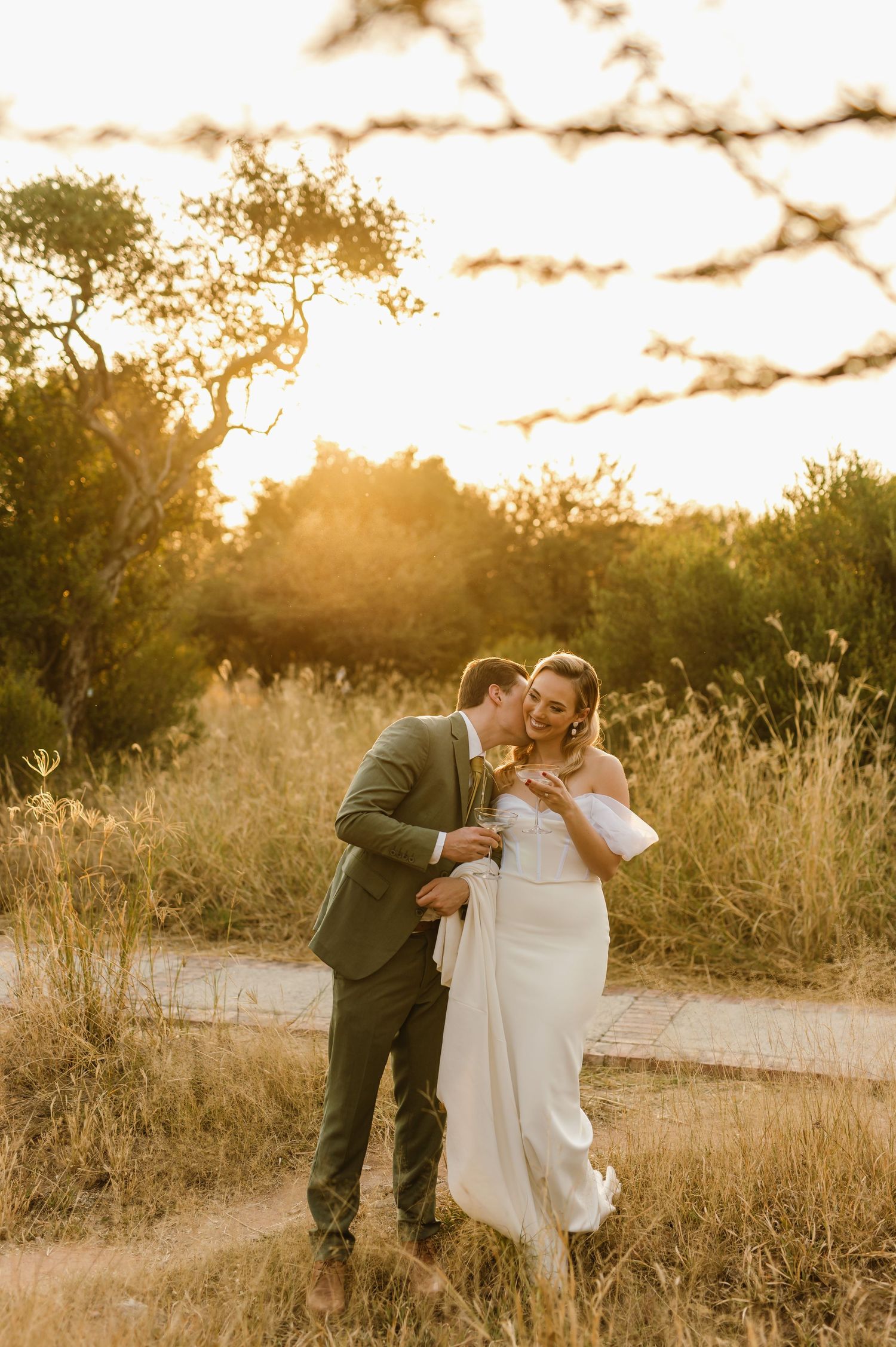 A couple shares a playful dip dance move on a rustic path during sunset.