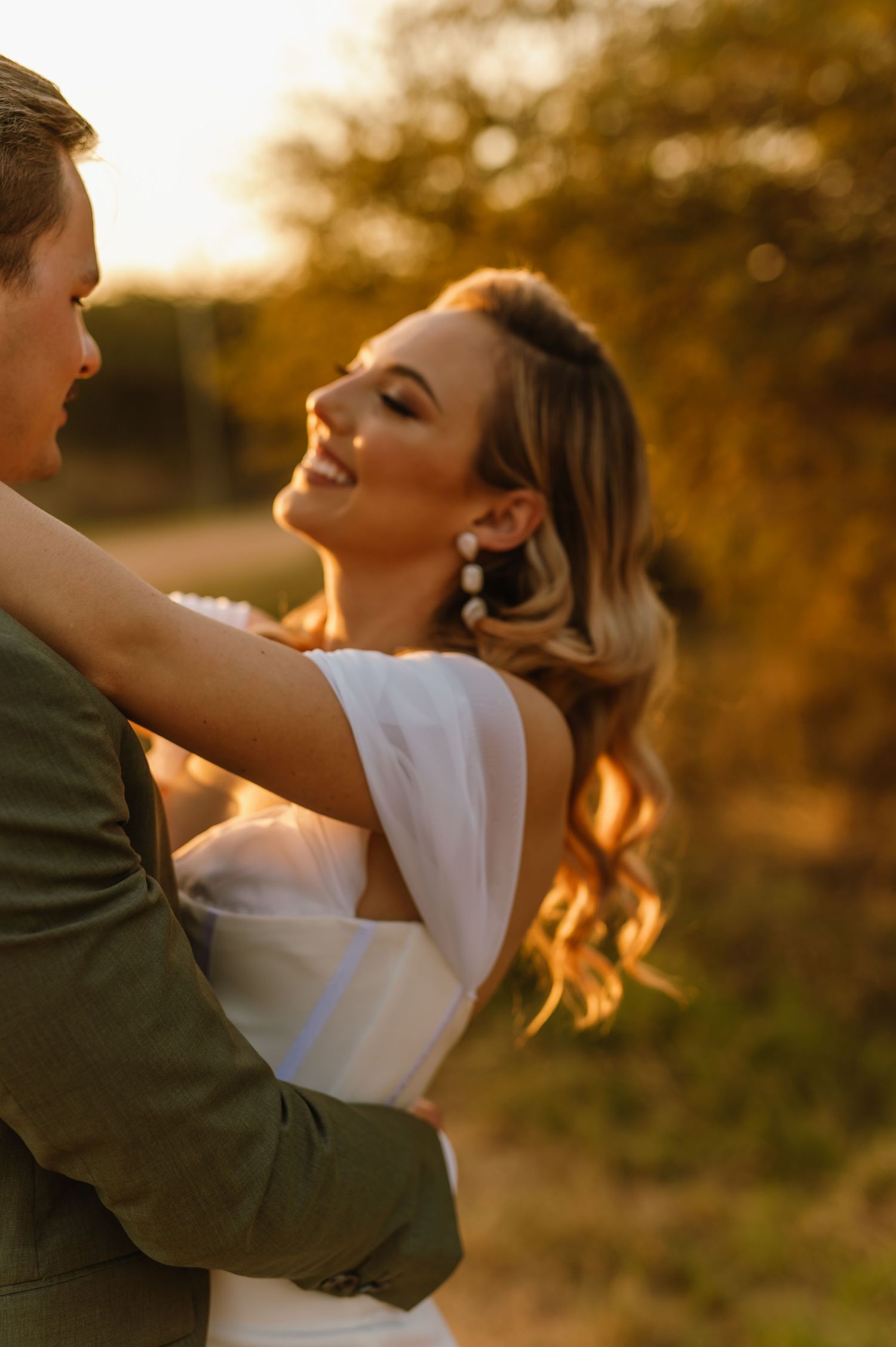 Couple dancing and laughing together during golden hour photography session.