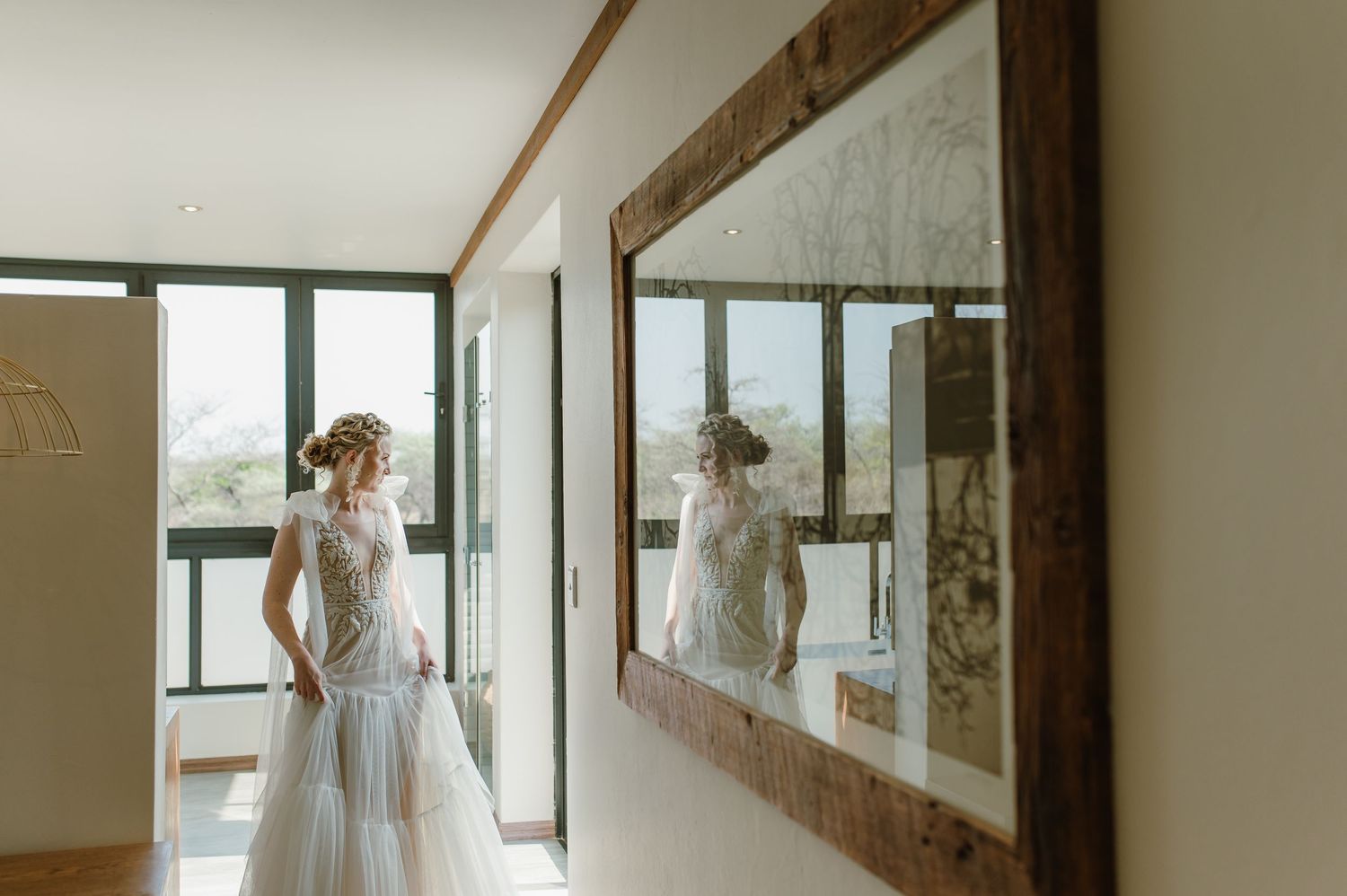 Modern bridal preparation room with natural light streaming through large windows.
