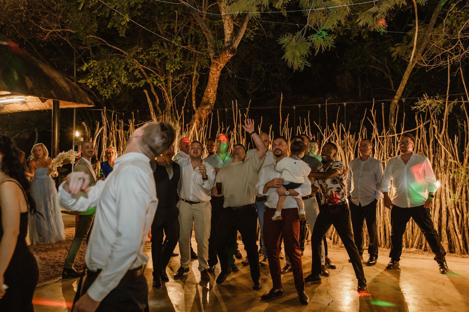 Guests dancing and celebrating at an outdoor evening wedding reception.