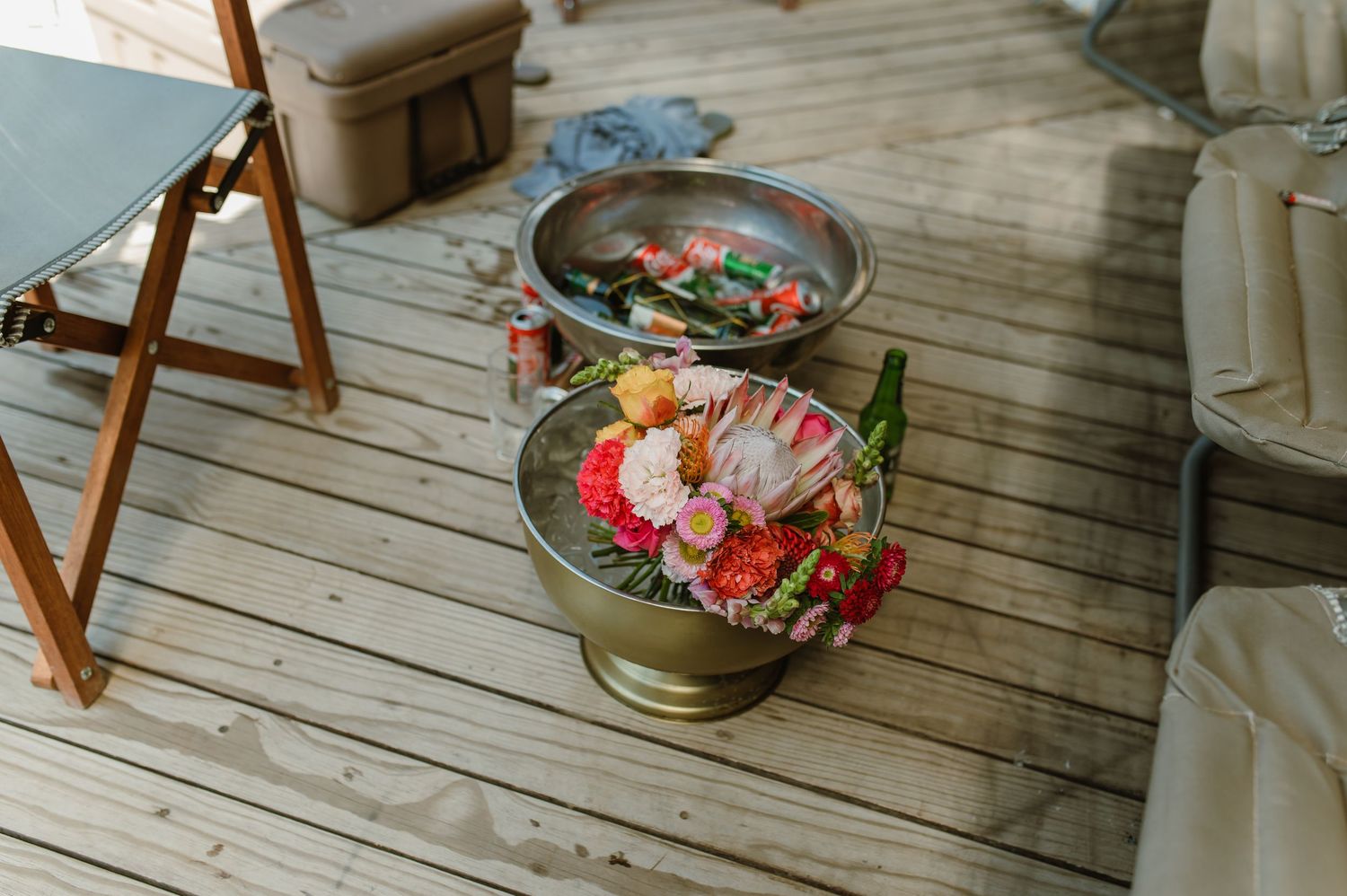 Wooden deck with decorative floral arrangements and seating setup for an outdoor event.