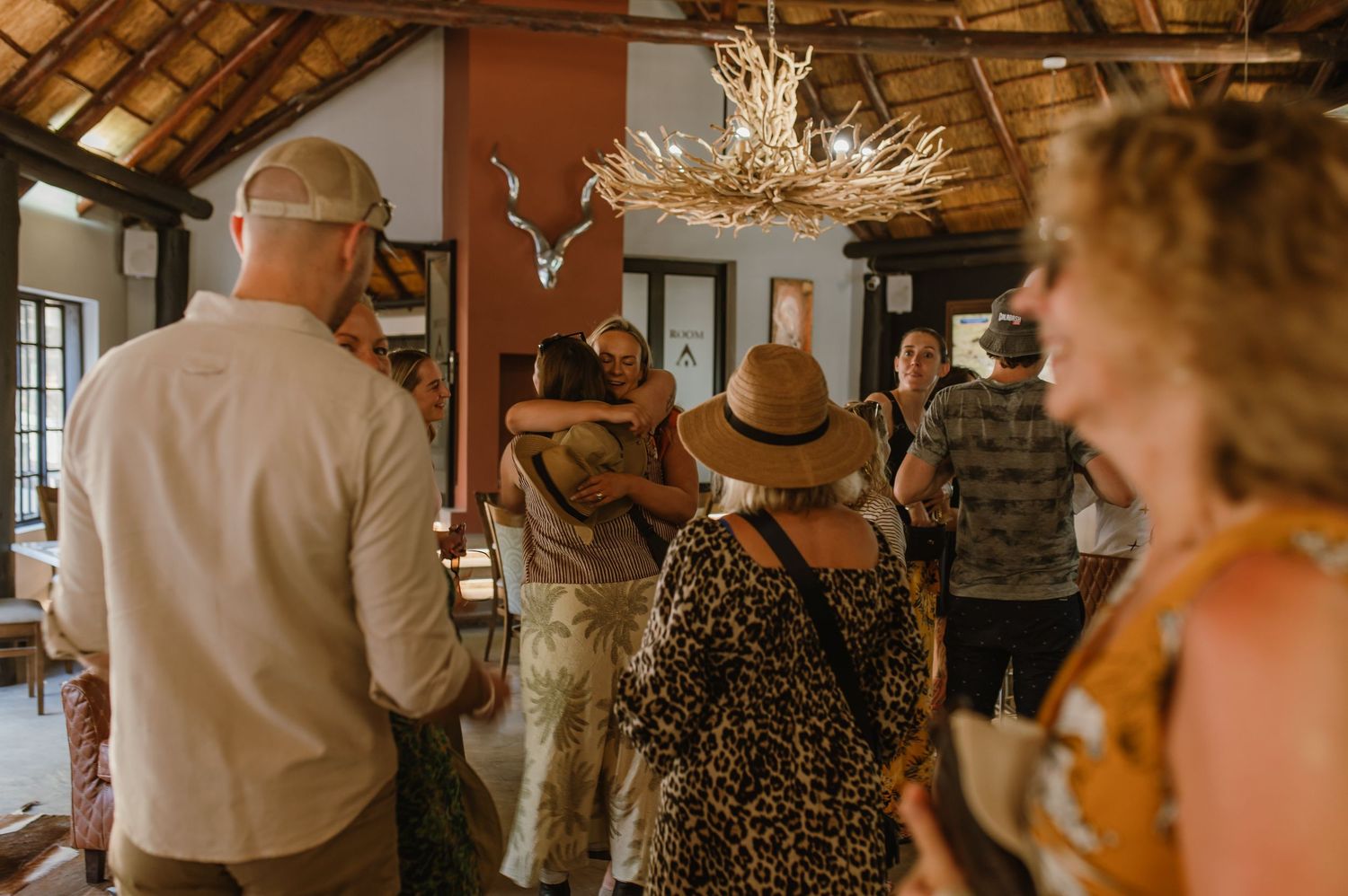 Interior of rustic venue with exposed wooden beams and thatched roof.