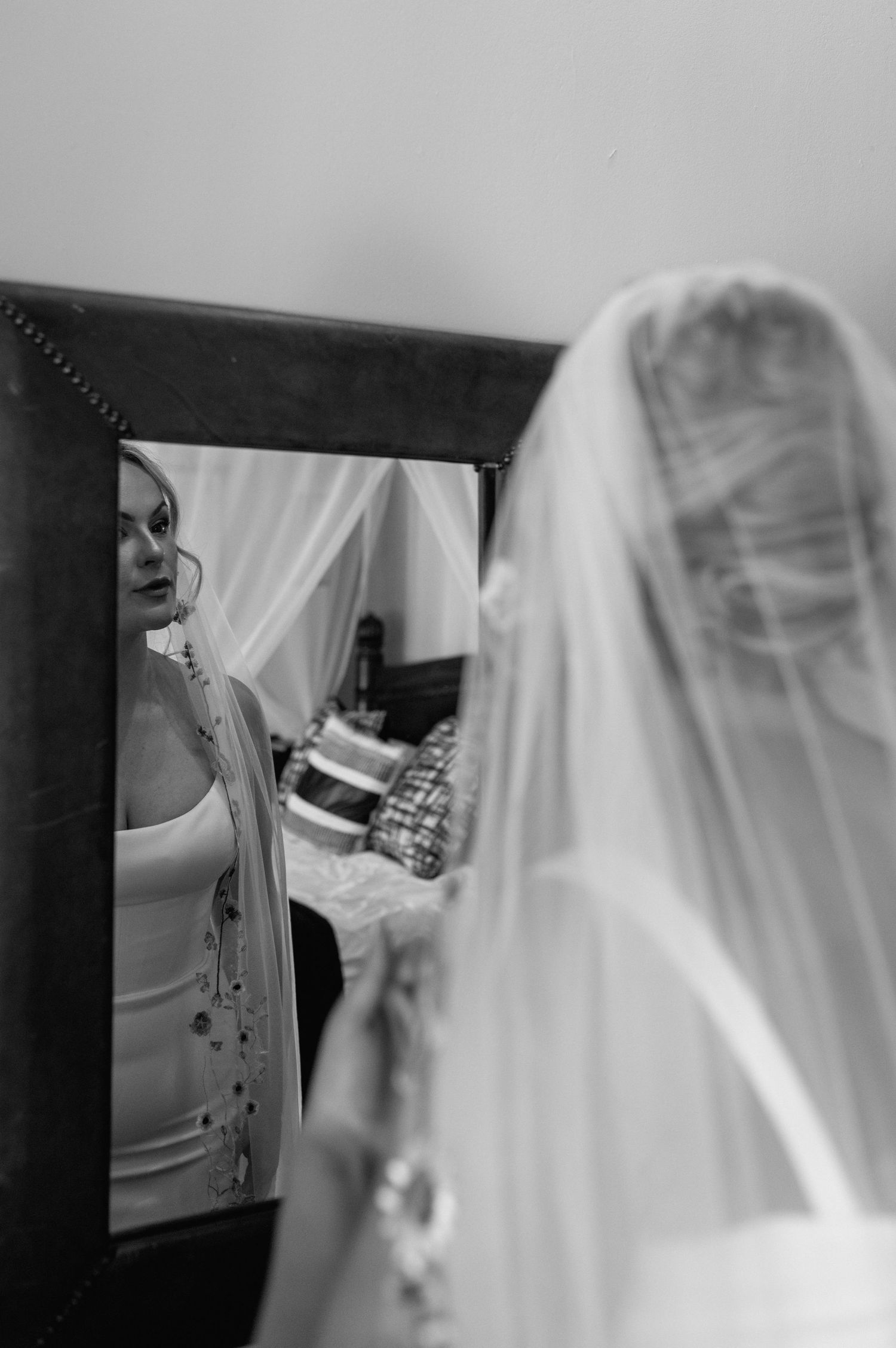 Black and white photo of wedding veil and dress preparation details.