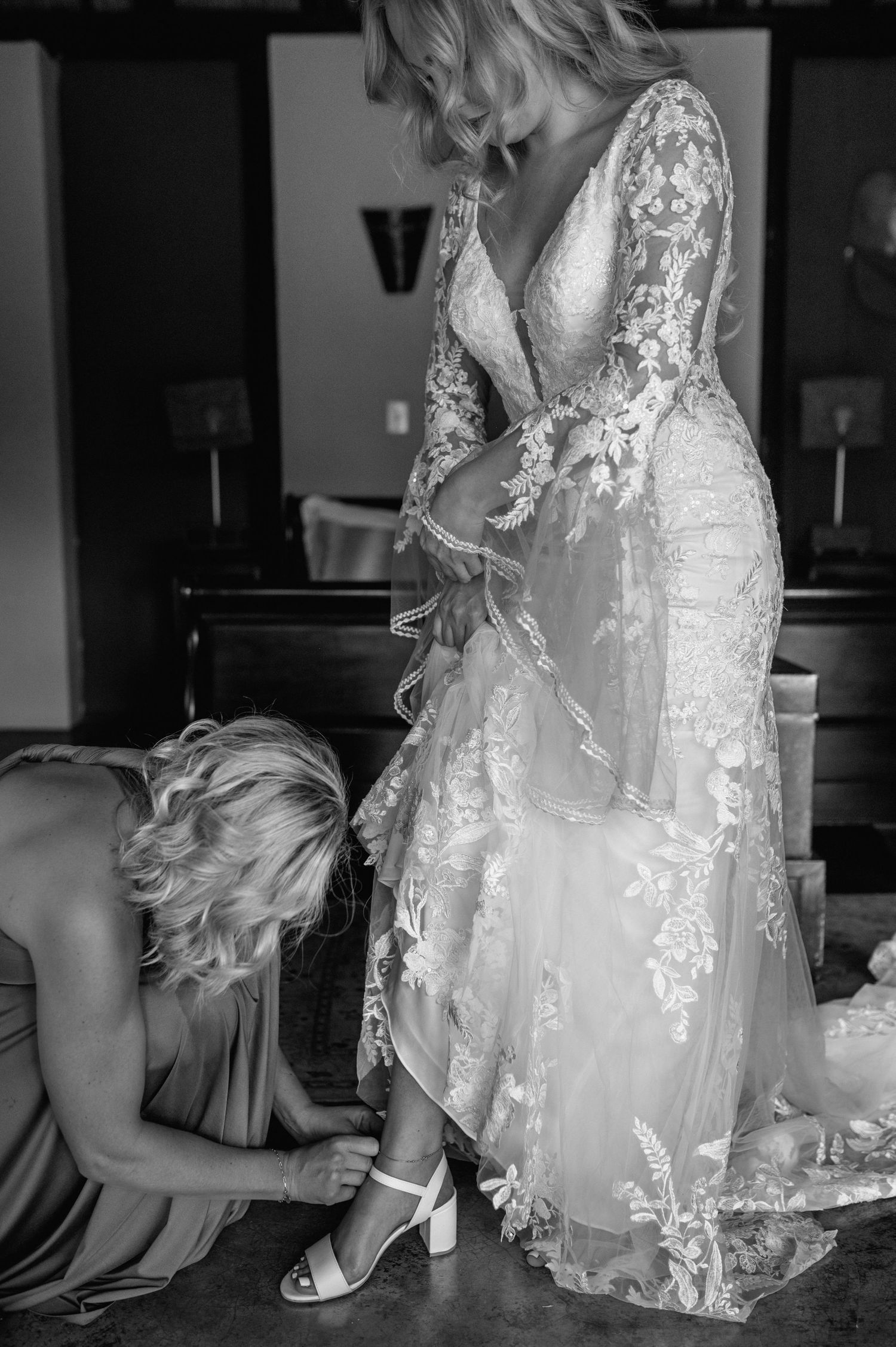 Detailed shot of a bride's wedding dress with intricate lace patterns and flowing fabric.