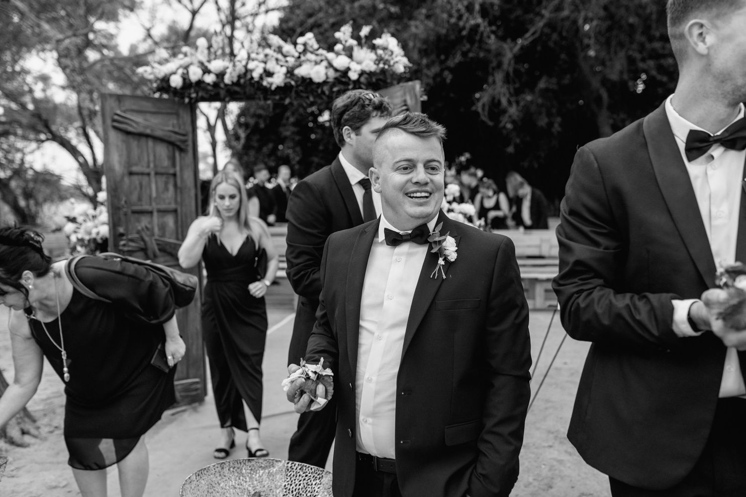 Wedding guests in formal attire share joyful moments during an outdoor celebration.