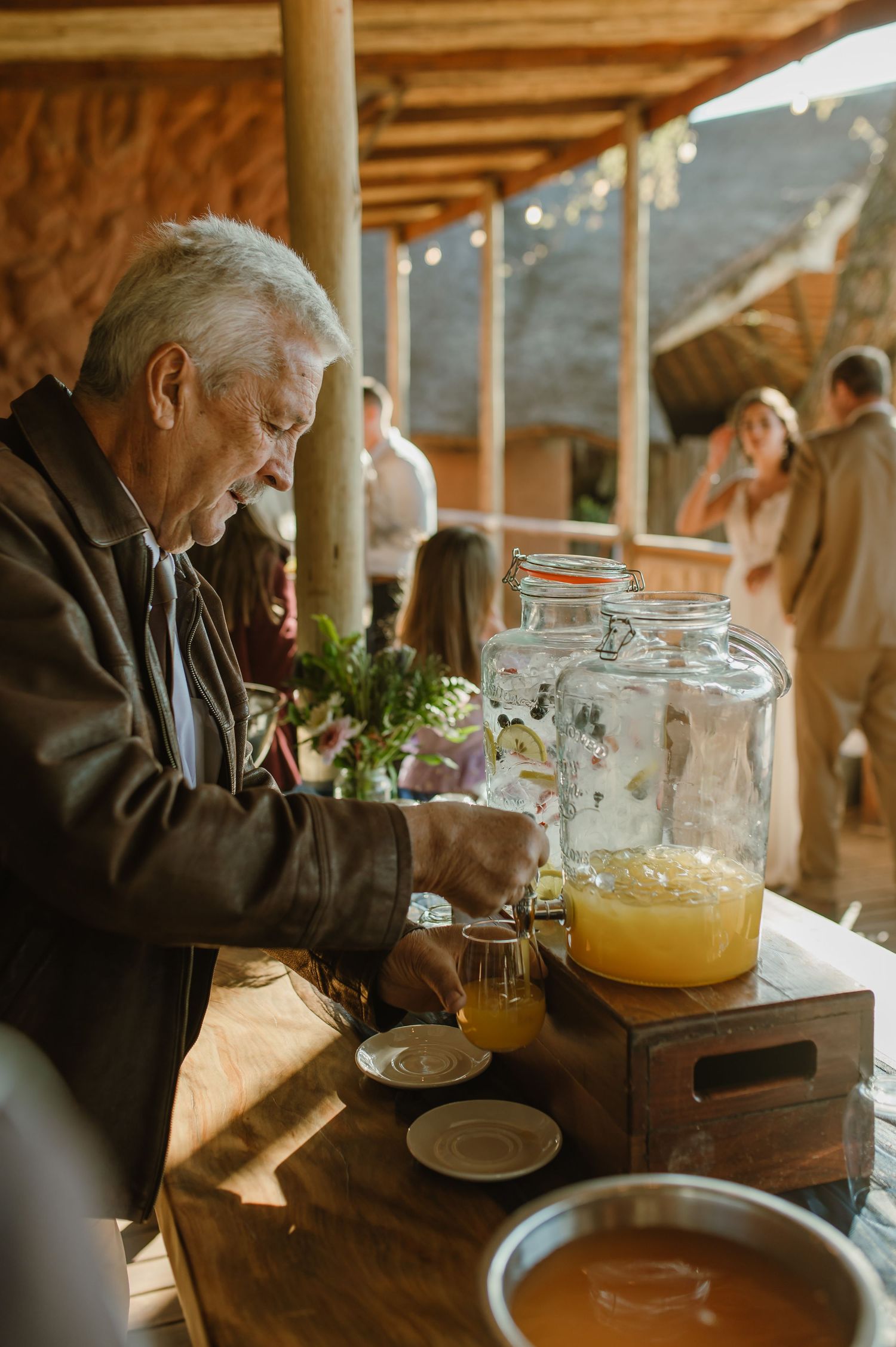 Guest enjoying refreshments at rustic wooden table during wedding reception.