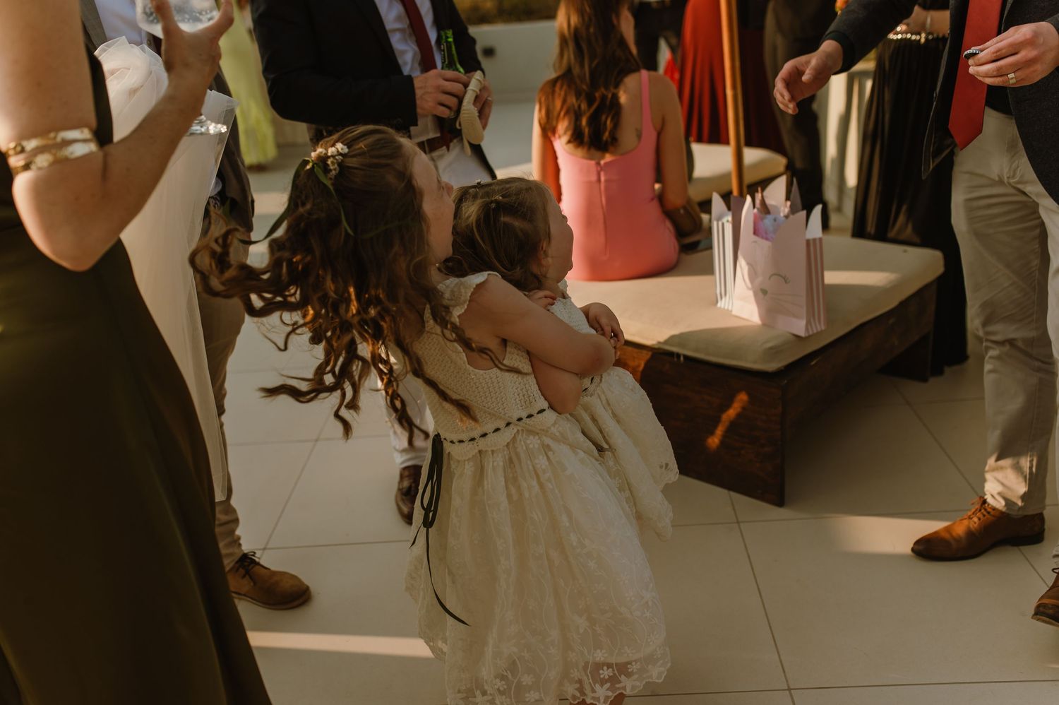 Young girl in white dress twirls on dance floor during celebration.
