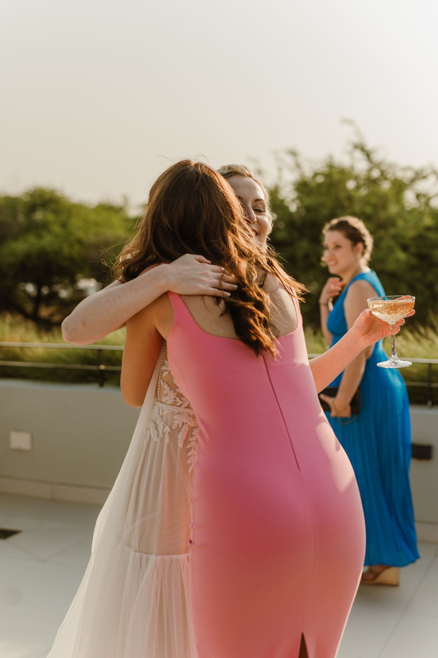Wedding party celebrating with champagne on an outdoor terrace.
