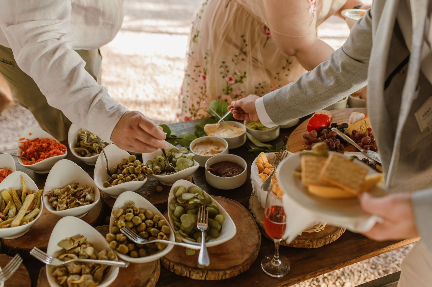 Wedding reception appetizers and drinks served on rustic wooden table.