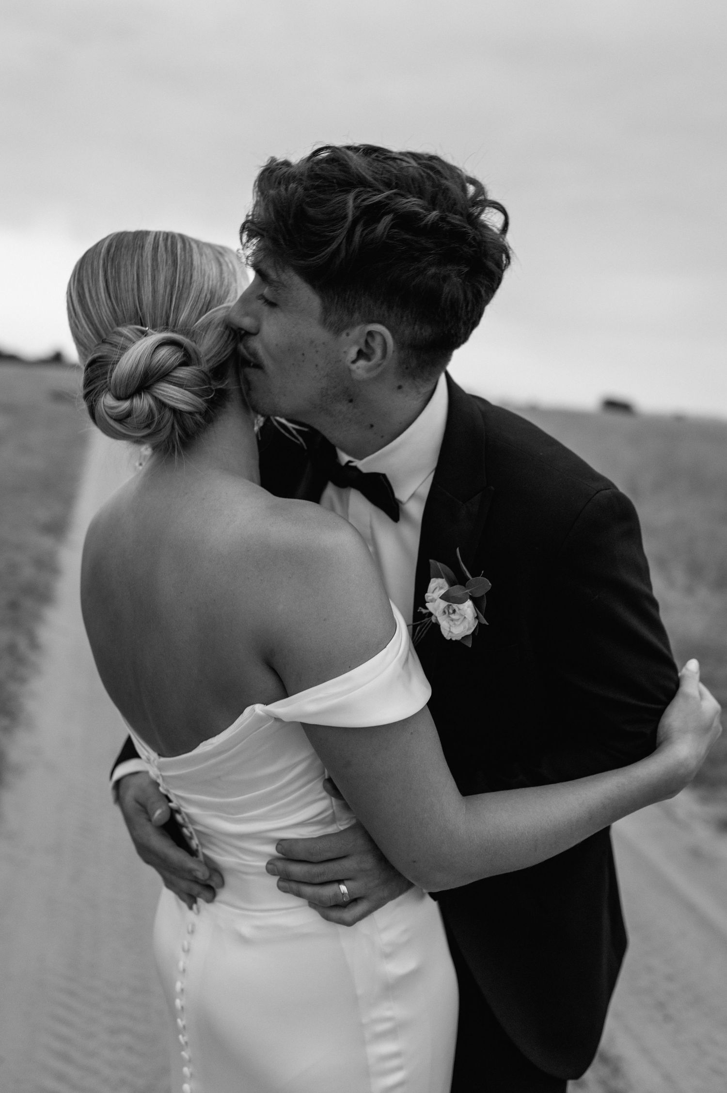Black and white wedding photos capturing romantic moments on a country path.