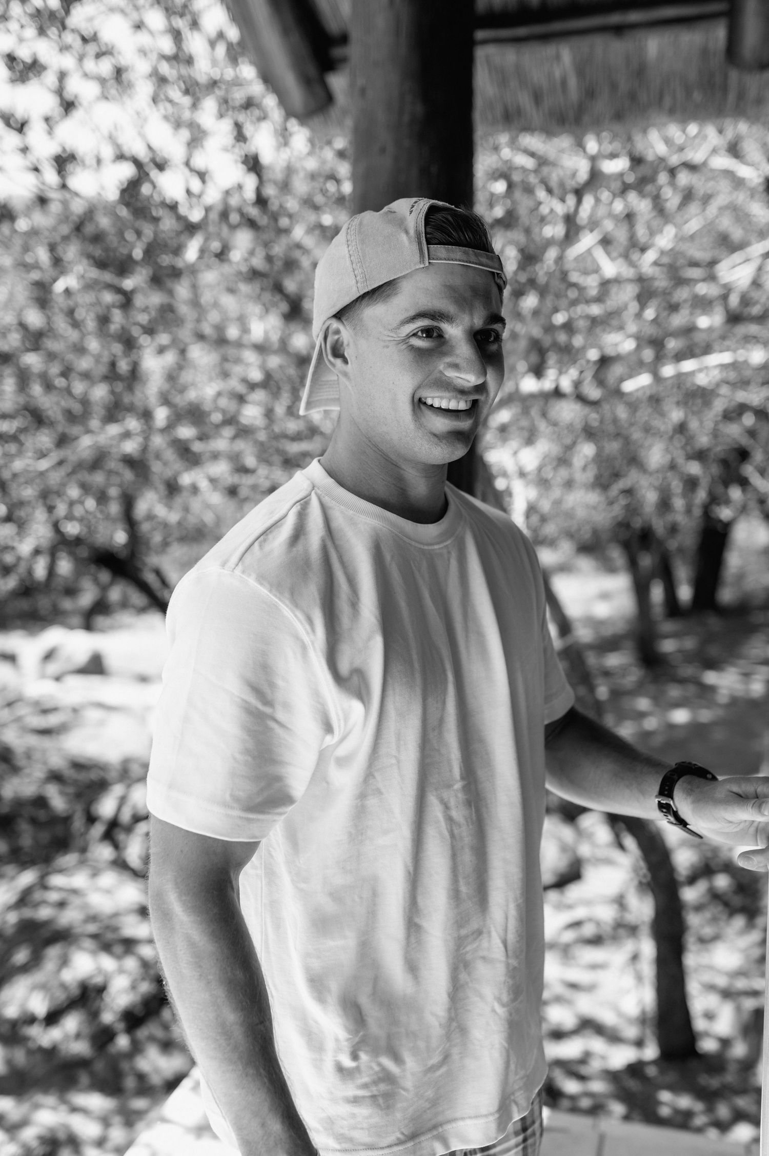 Black and white portrait of person in white shirt outdoors.