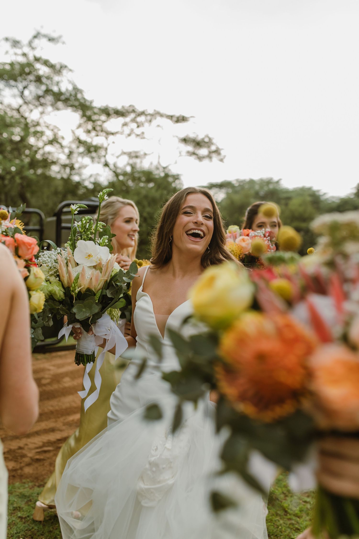 Joyful celebration captured during outdoor wedding with bright bouquets and natural scenery.