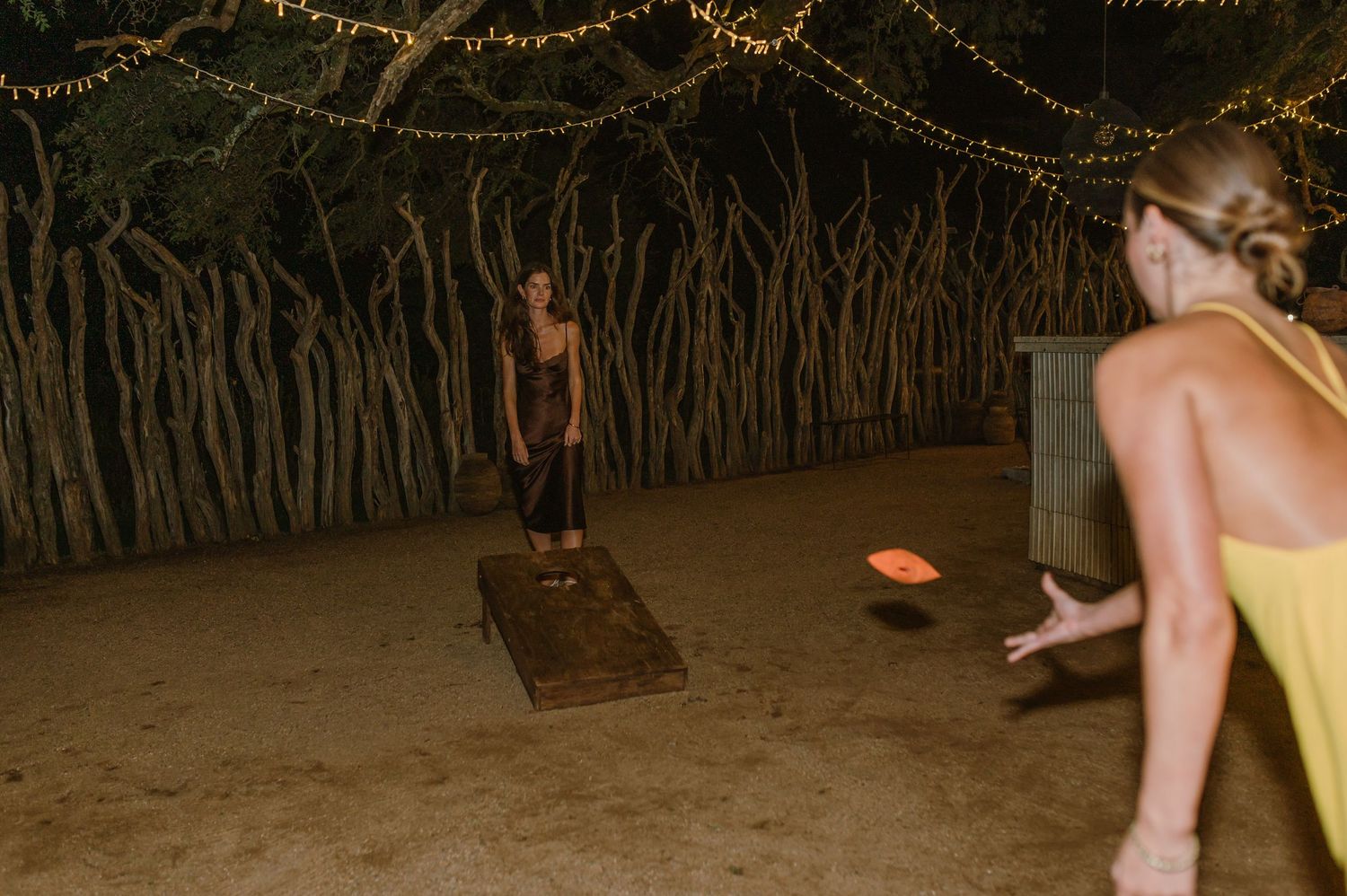 String lights illuminate an outdoor wedding venue at night.