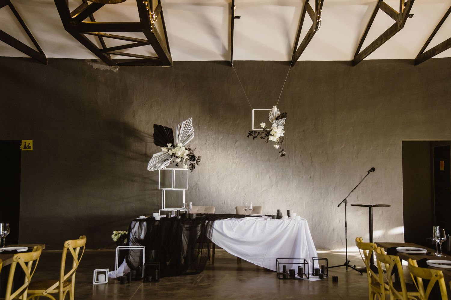 Large industrial event space with exposed ceiling beams and natural lighting.