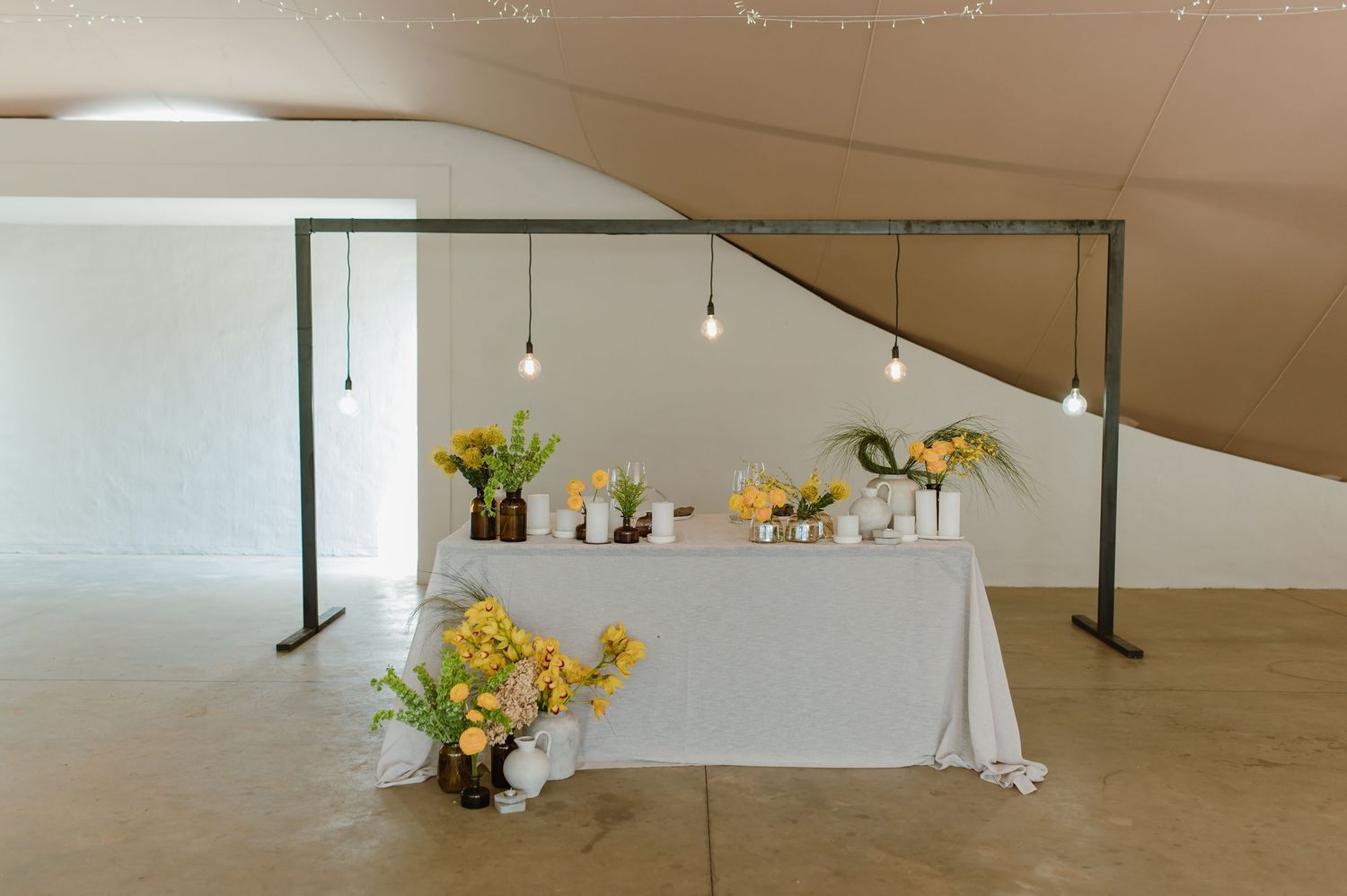 Modern minimalist interior space with white walls and subtle floral arrangements.