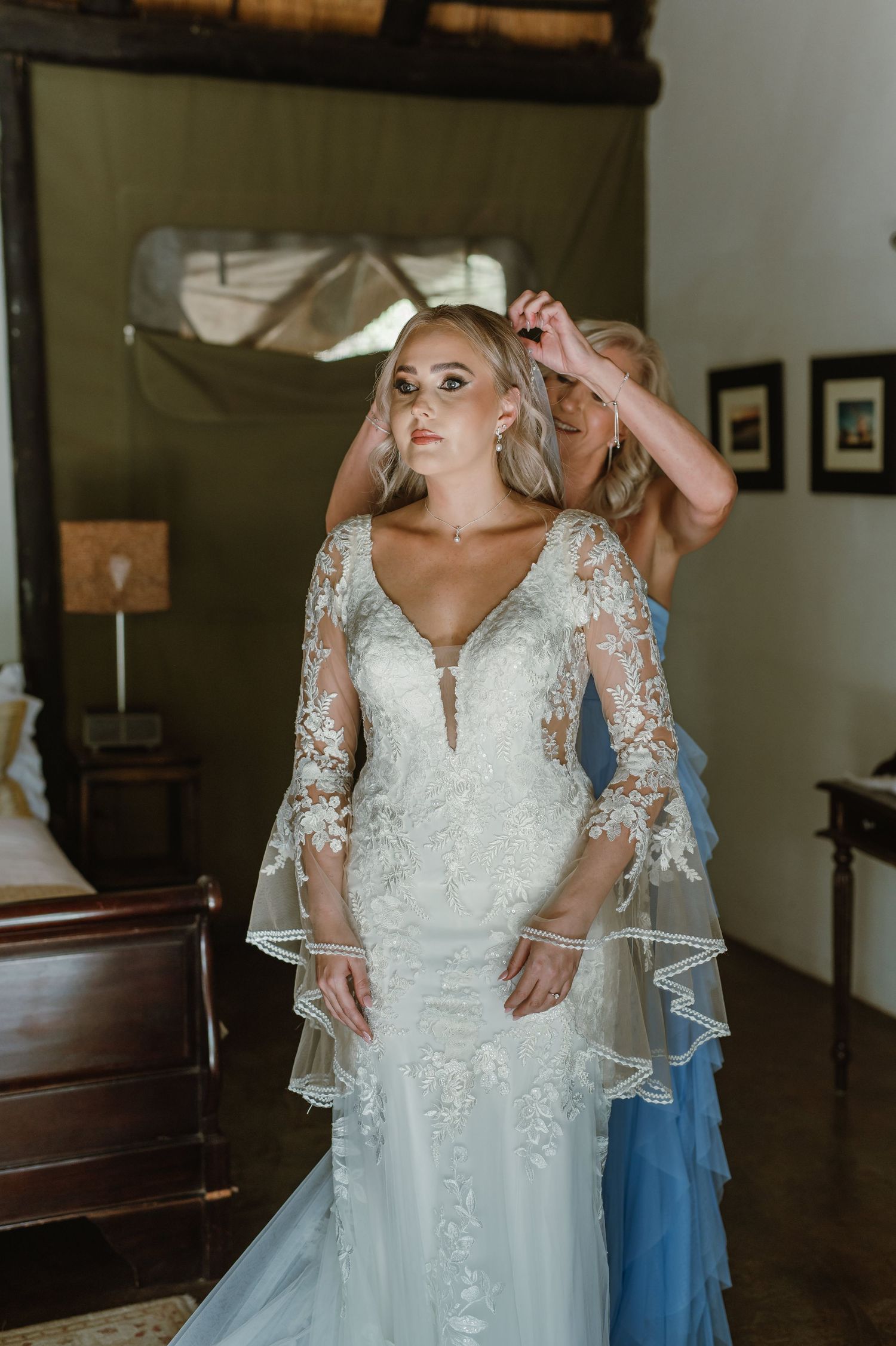 Wedding dress fitting session showing intricate lace details and flowing white gown in a church setting.
