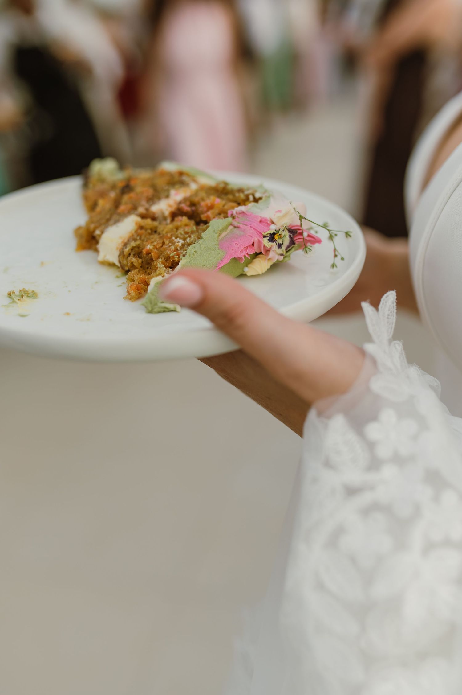 Beautifully plated food being served on a white plate with pink floral garnish.