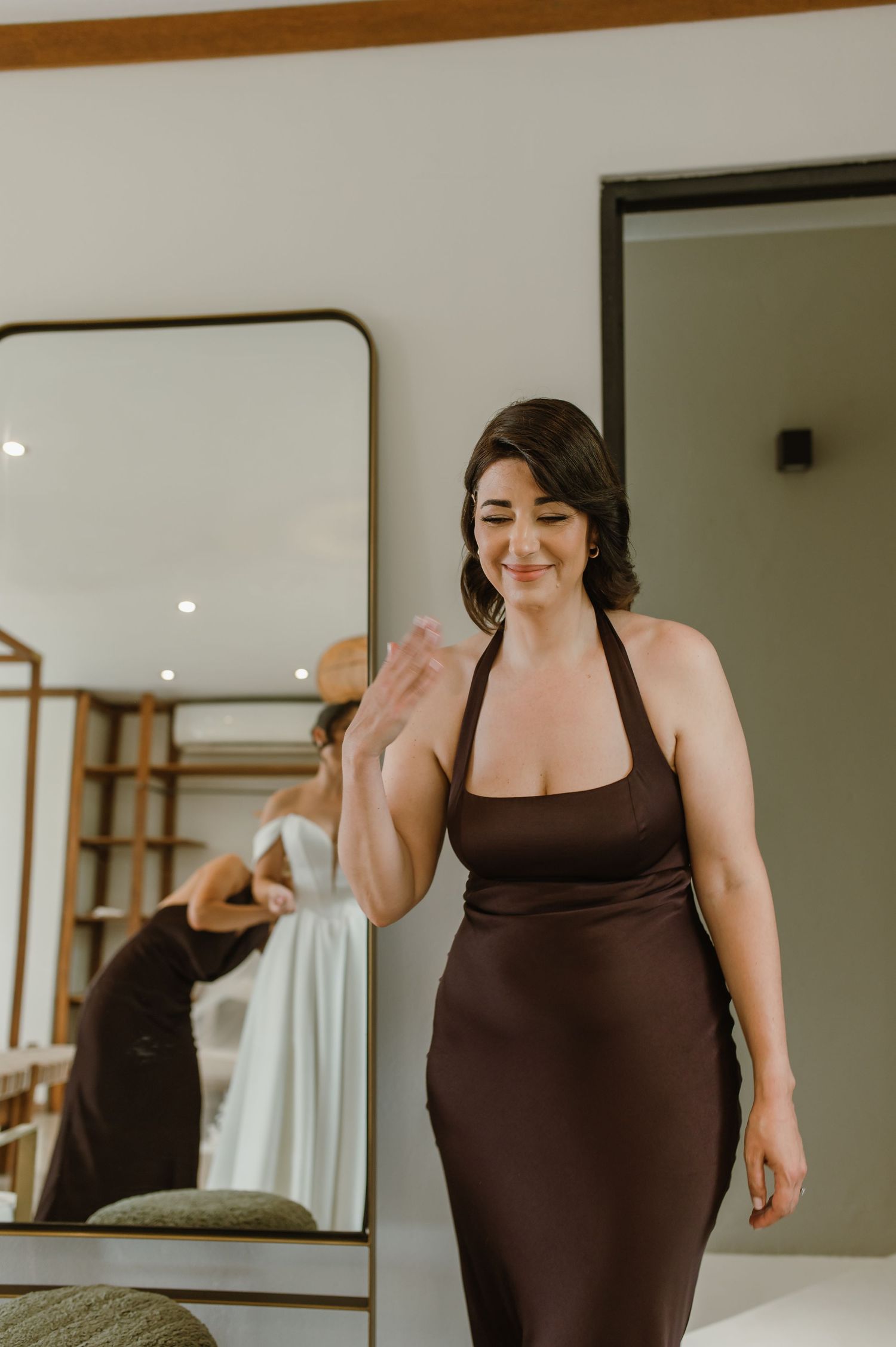 Woman in brown athletic wear moving in front of mirror during workout session.