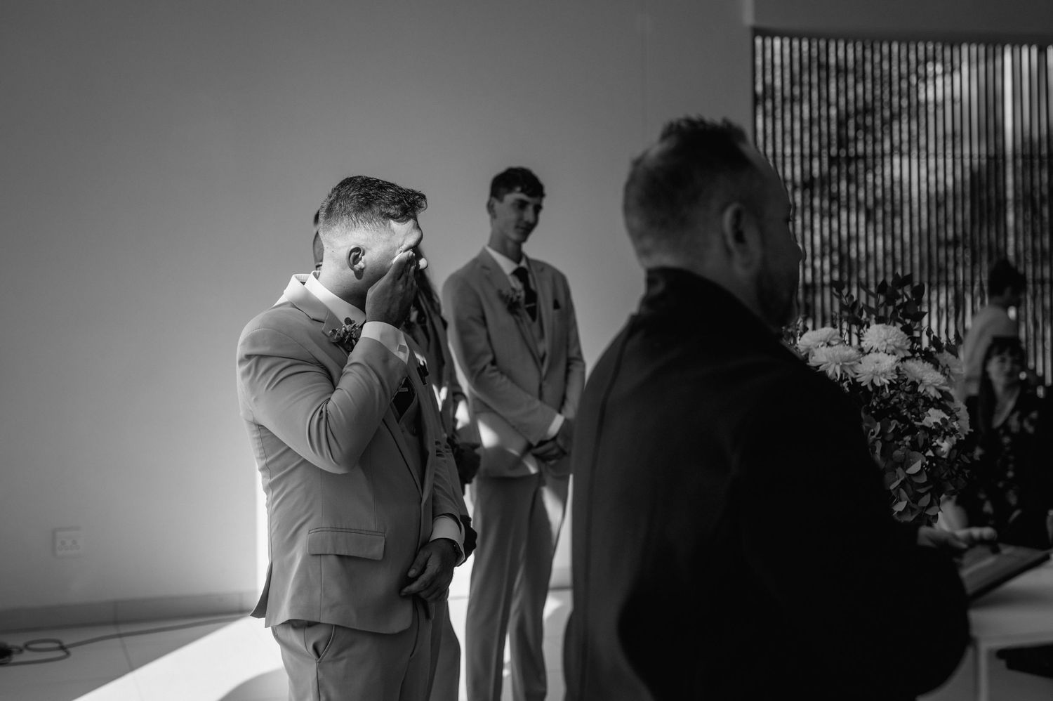 Black and white dramatic wedding ceremony moment in contemporary indoor setting.