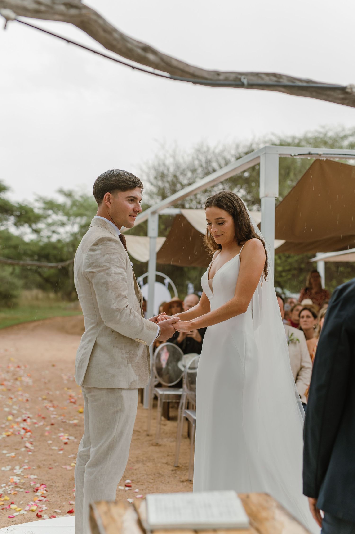 Couple shares emotional moment during ring exchange at desert wedding ceremony.