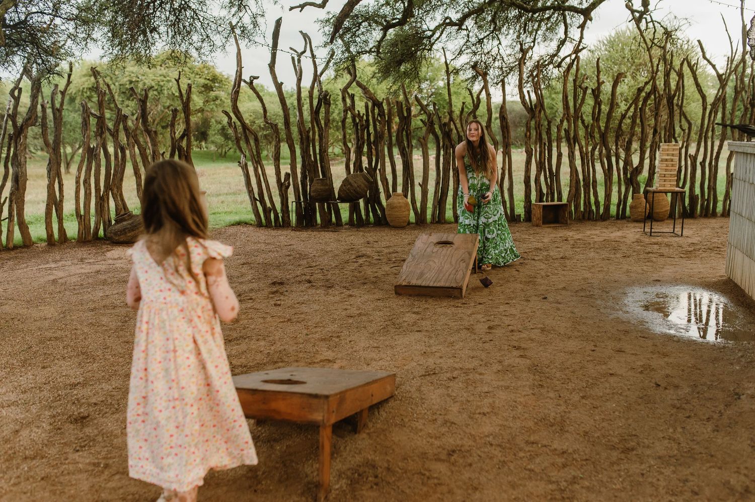Rustic outdoor wedding venue setup with wooden furniture and natural decor under trees.