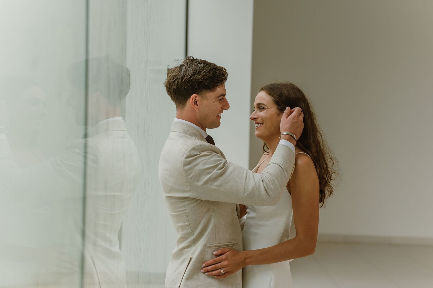 An intimate moment between newlyweds in a bright, modern interior setting.