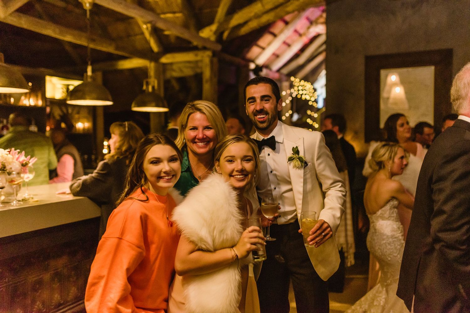 Wedding reception in a rustic wooden barn venue with ambient lighting and festive decorations.