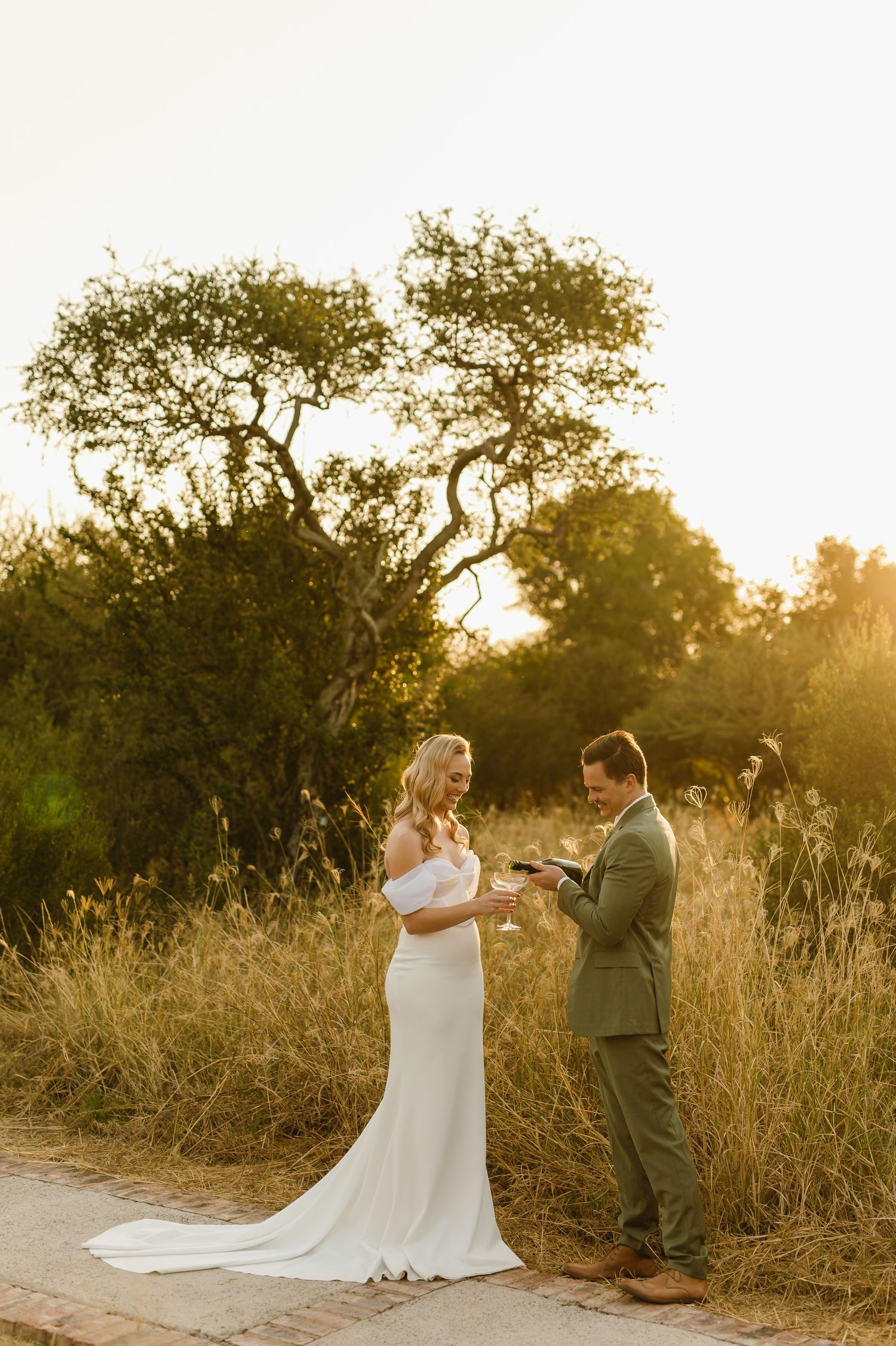 Couple reading personal vows to each other during an outdoor sunset ceremony.