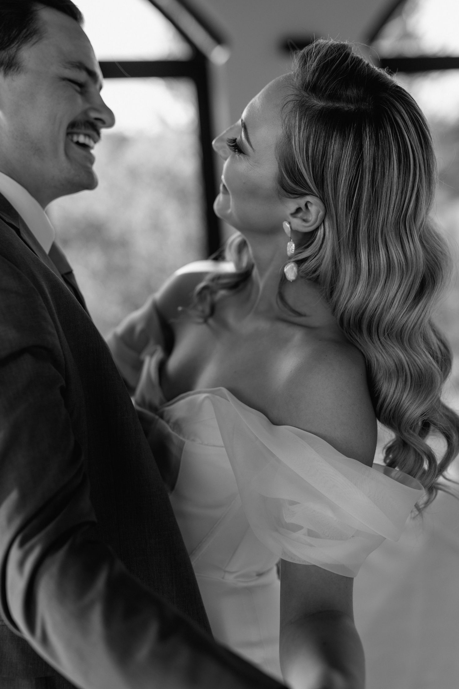 Black and white intimate wedding portrait showing tender romantic moment between newlyweds.