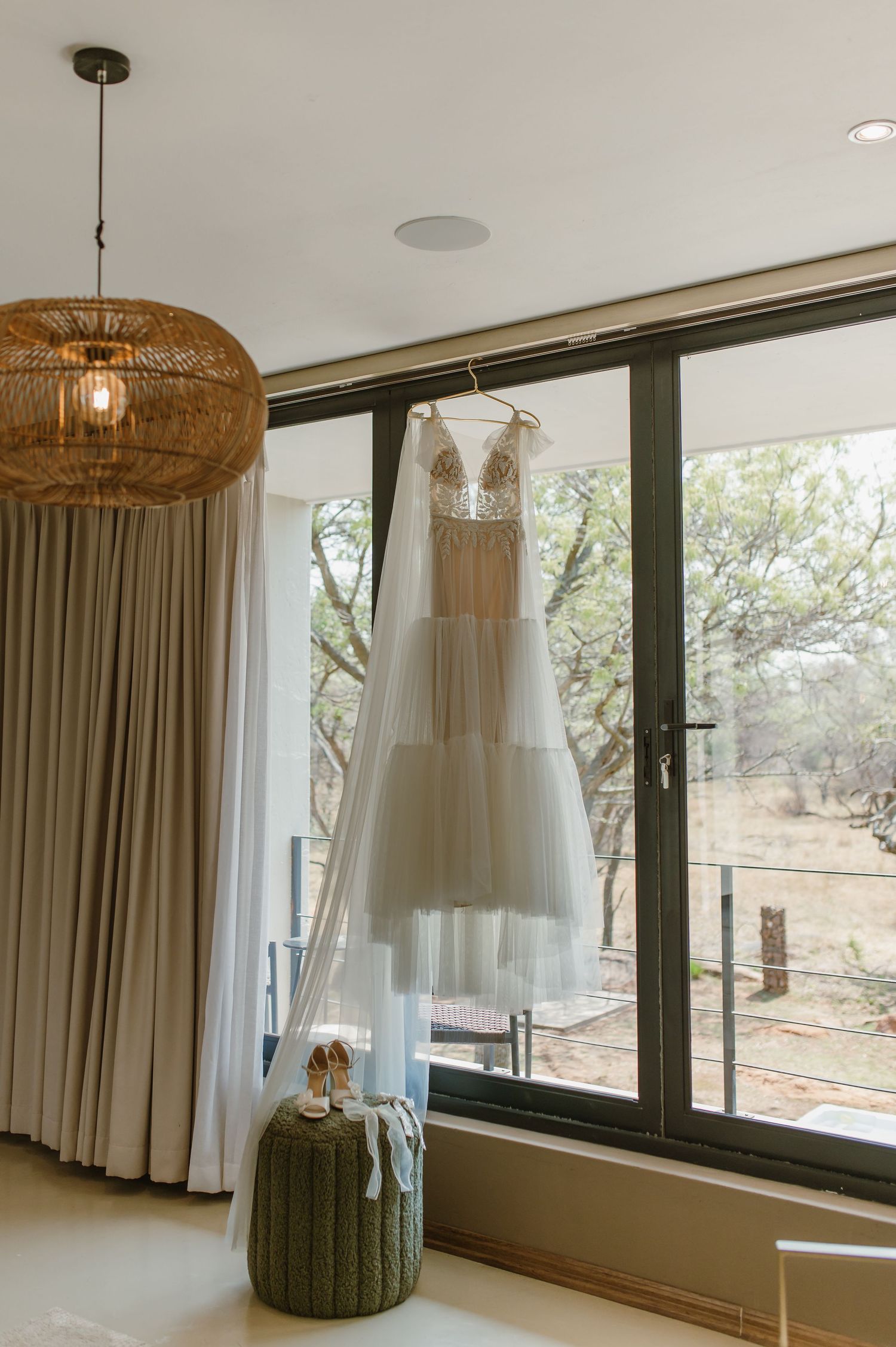 Interior room with floor-to-ceiling windows and woven pendant lights hanging from the ceiling.