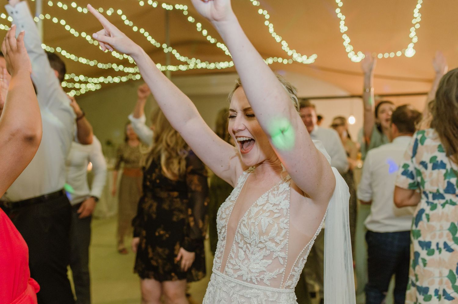 Festive dance party scene with string lights overhead and guests enjoying themselves.