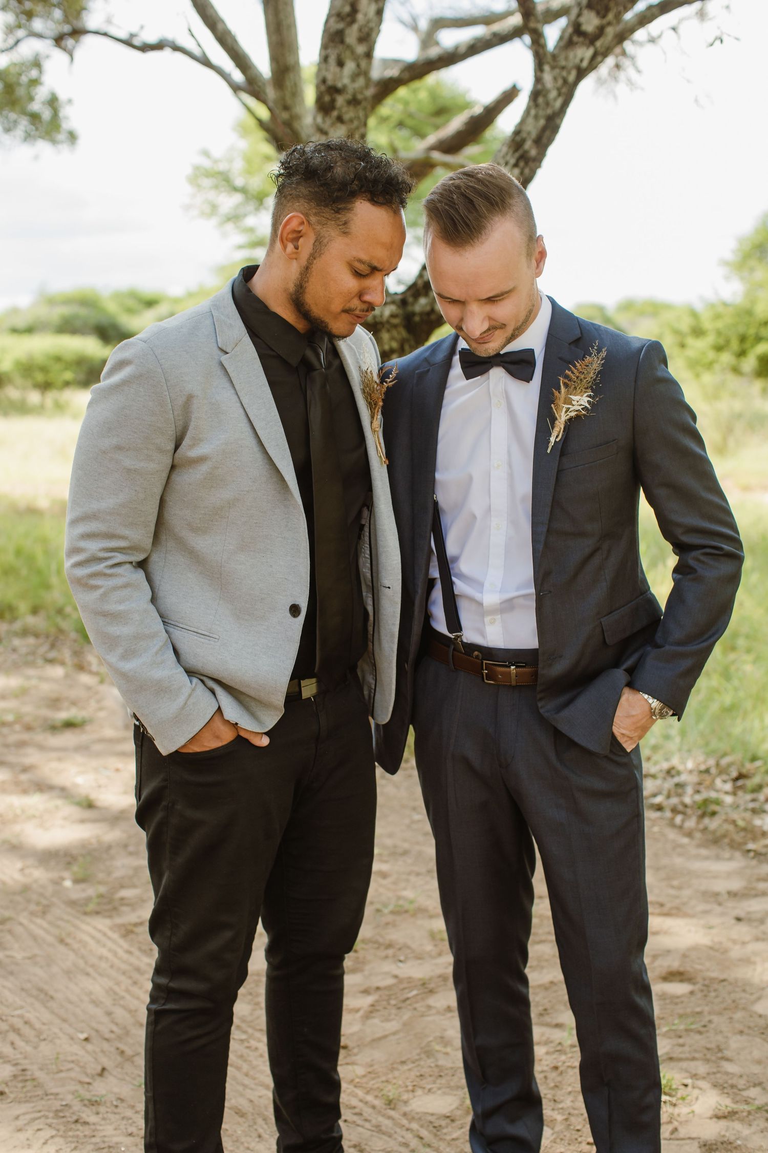 Wedding party members in formal attire looking down at something together.